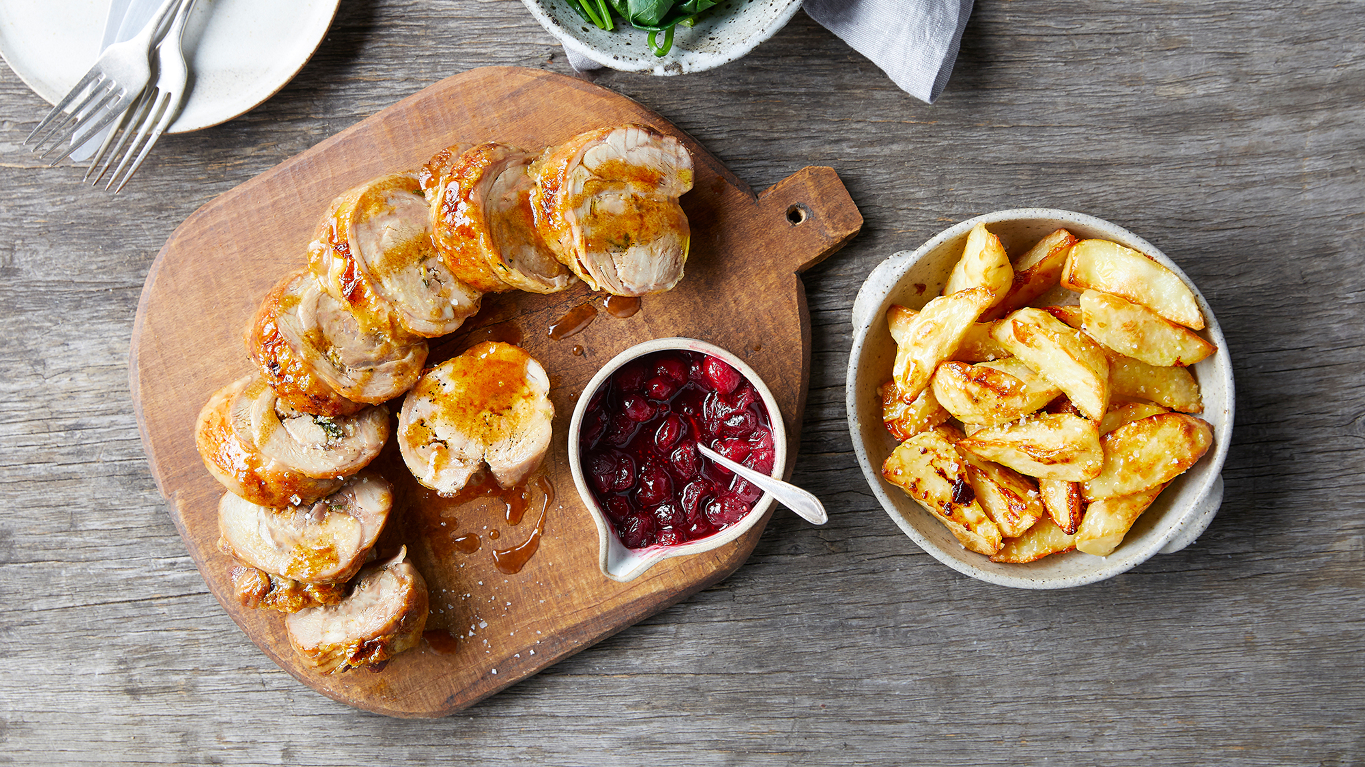 Centr's Roast Turkey Roll with Easy Cranberry Sauce rests on a board, ready for serving
