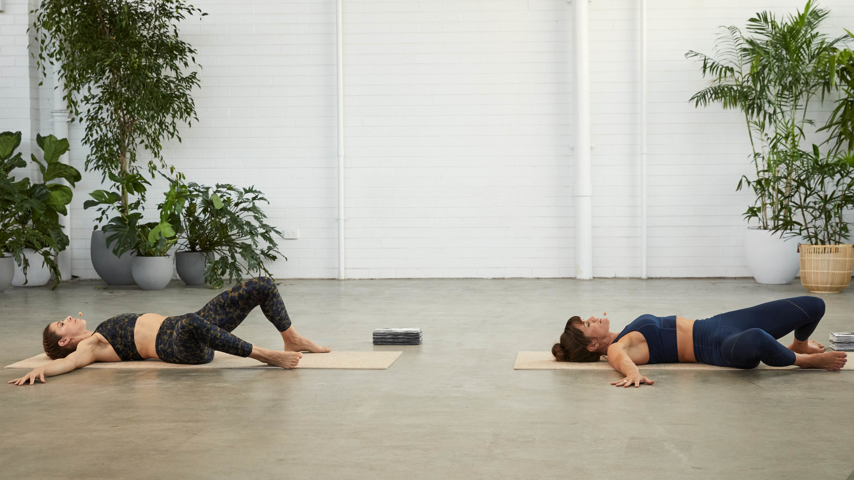 Tahl Rinsky and Sylvia Roberts demonstrate the reclined twist yoga pose.