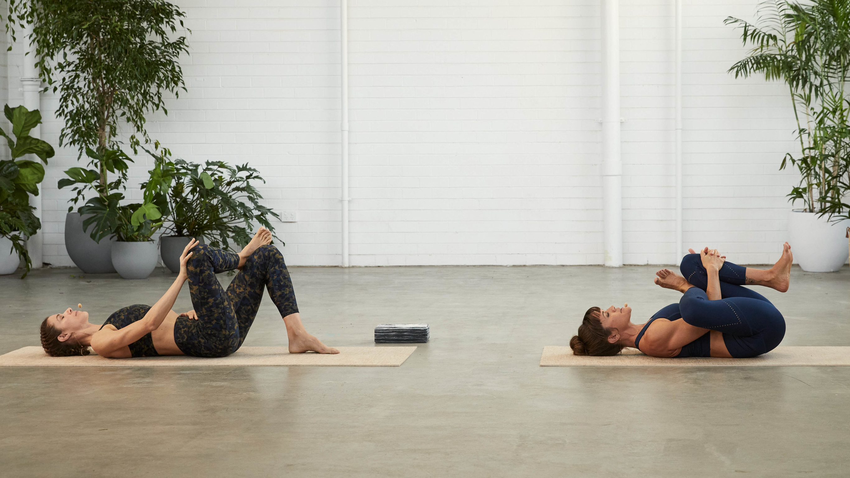 Tahl Rinsky and Sylvia Roberts demonstrate the reclined figure 4 yoga pose.