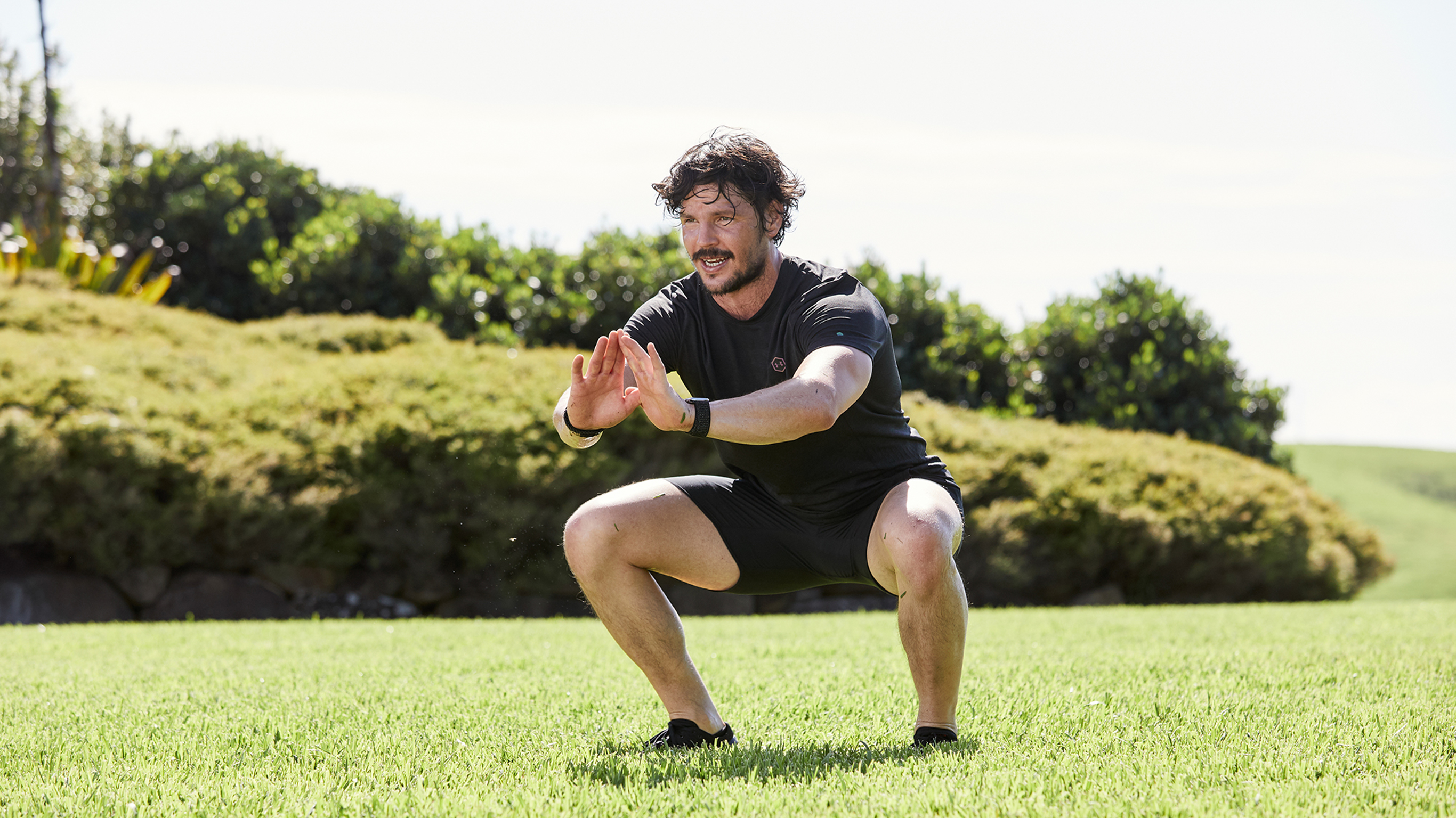 Dan Churchill does a bodyweight squat outside.