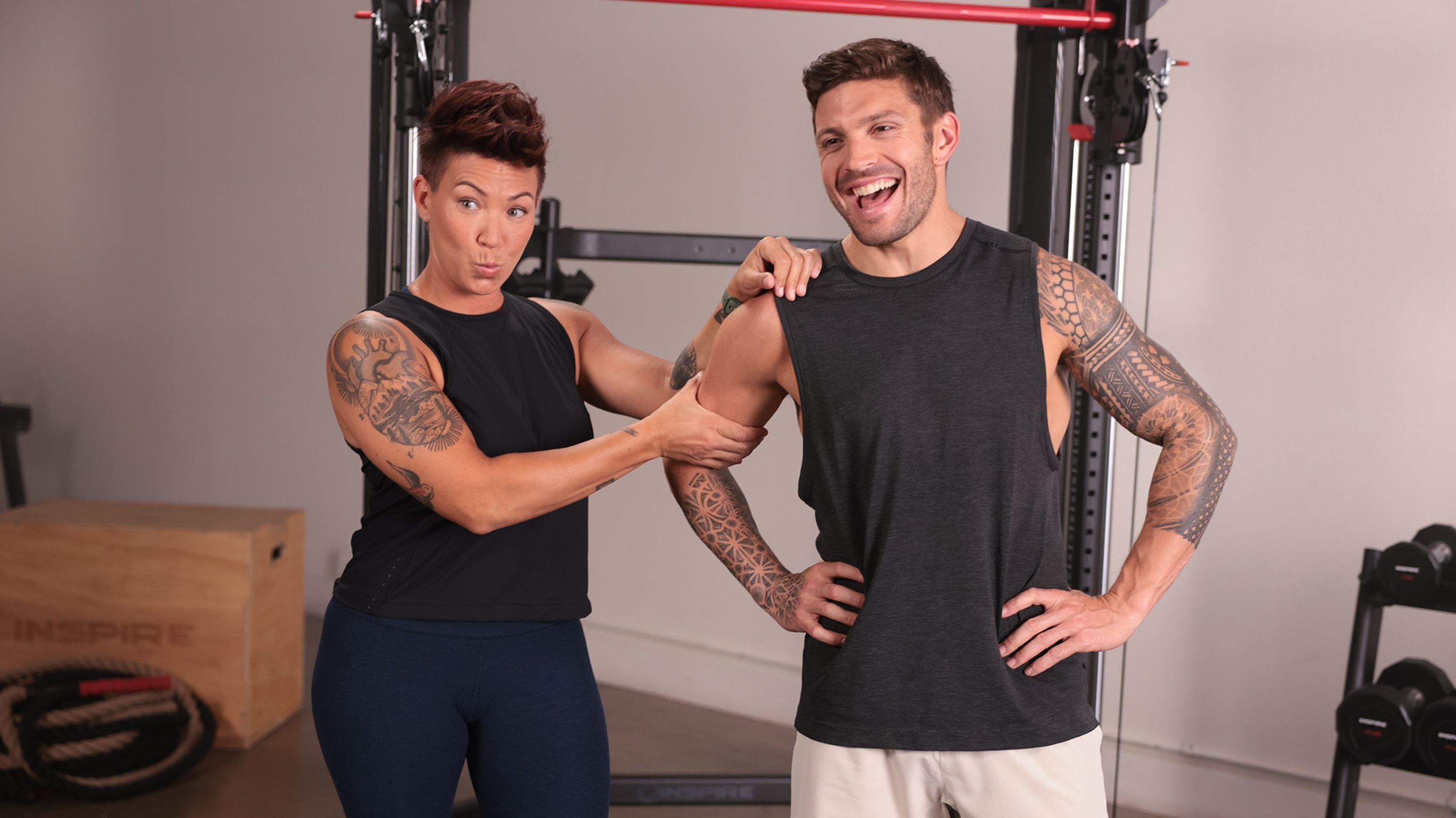 Jess Kilts raises her eyebrows in pretend surprise, as she squeezes Luke Zocchi's bicep.