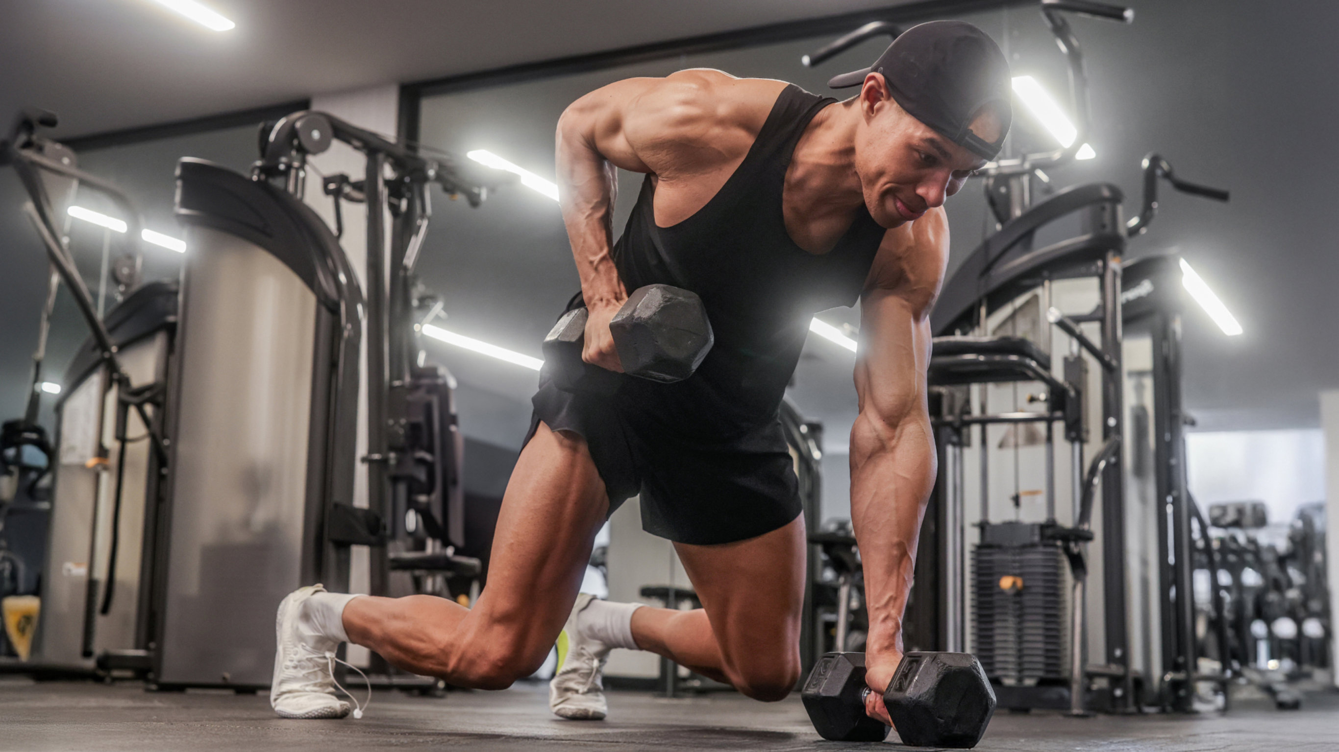 Korey Rowe performs plank dumbbell rows in a gym.