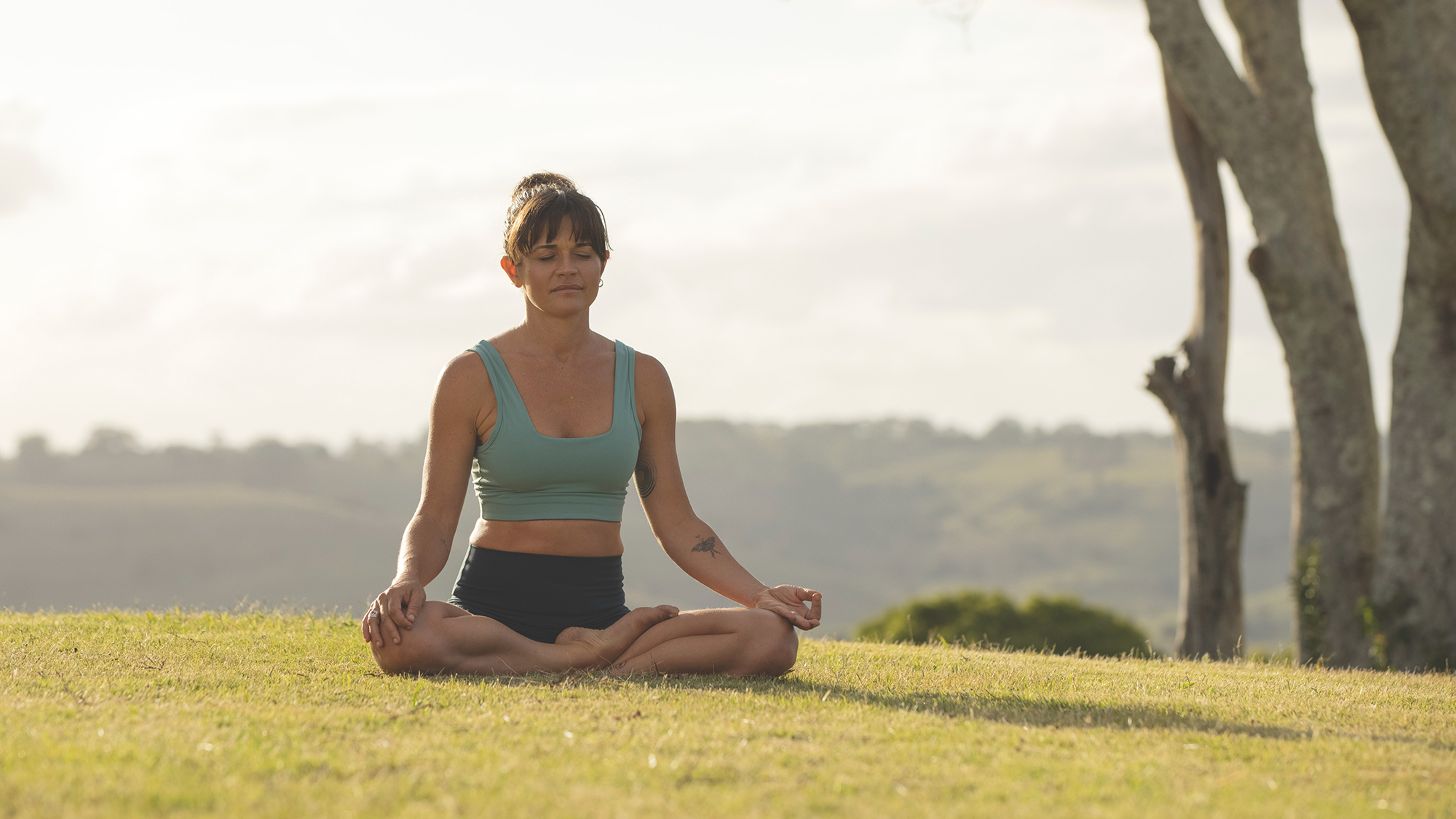 A woman meditates in the outdoors.