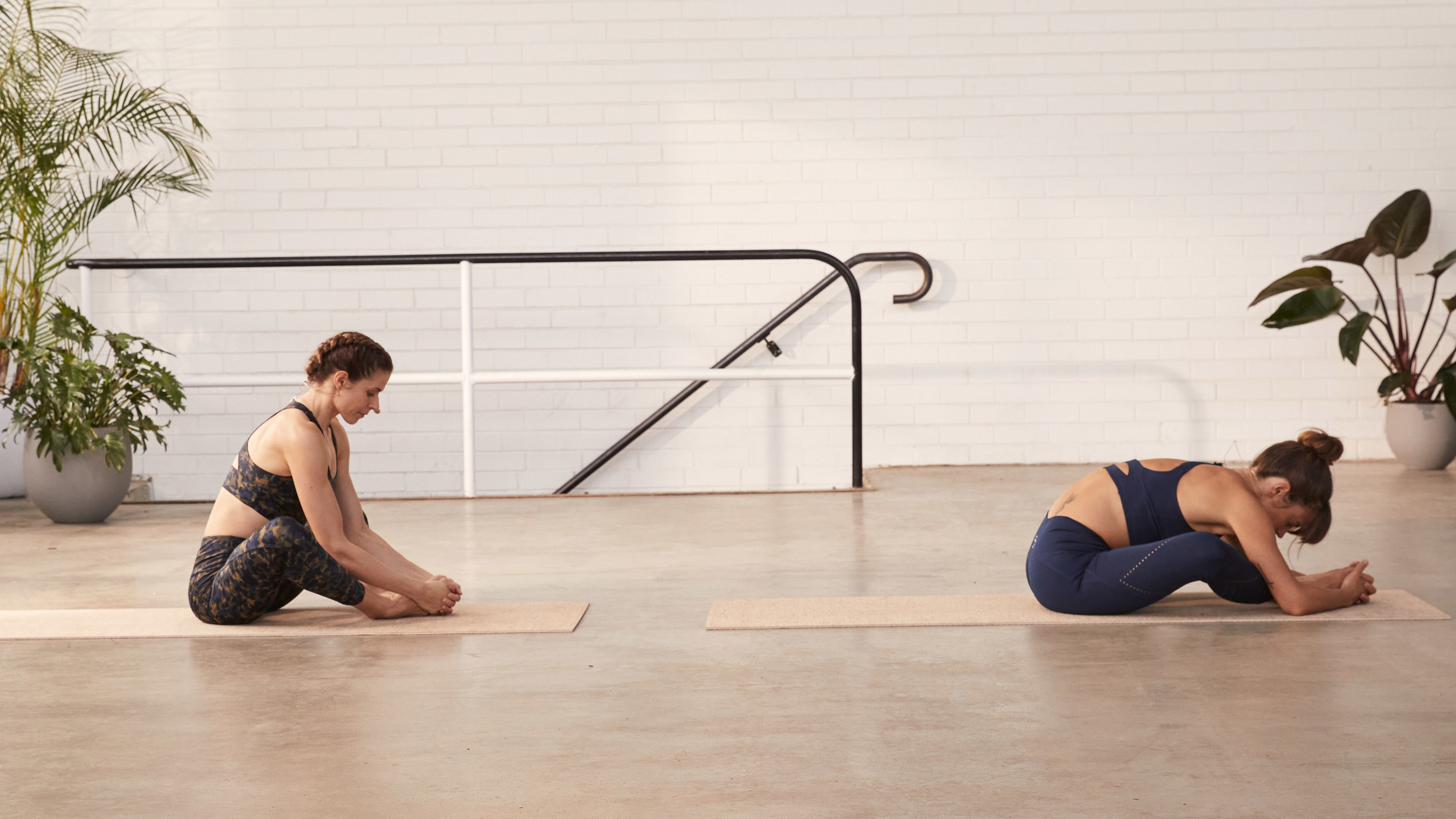 Tahl Rinsky and Sylvia Roberts perform a relaxing butterfly pose during a yoga class.