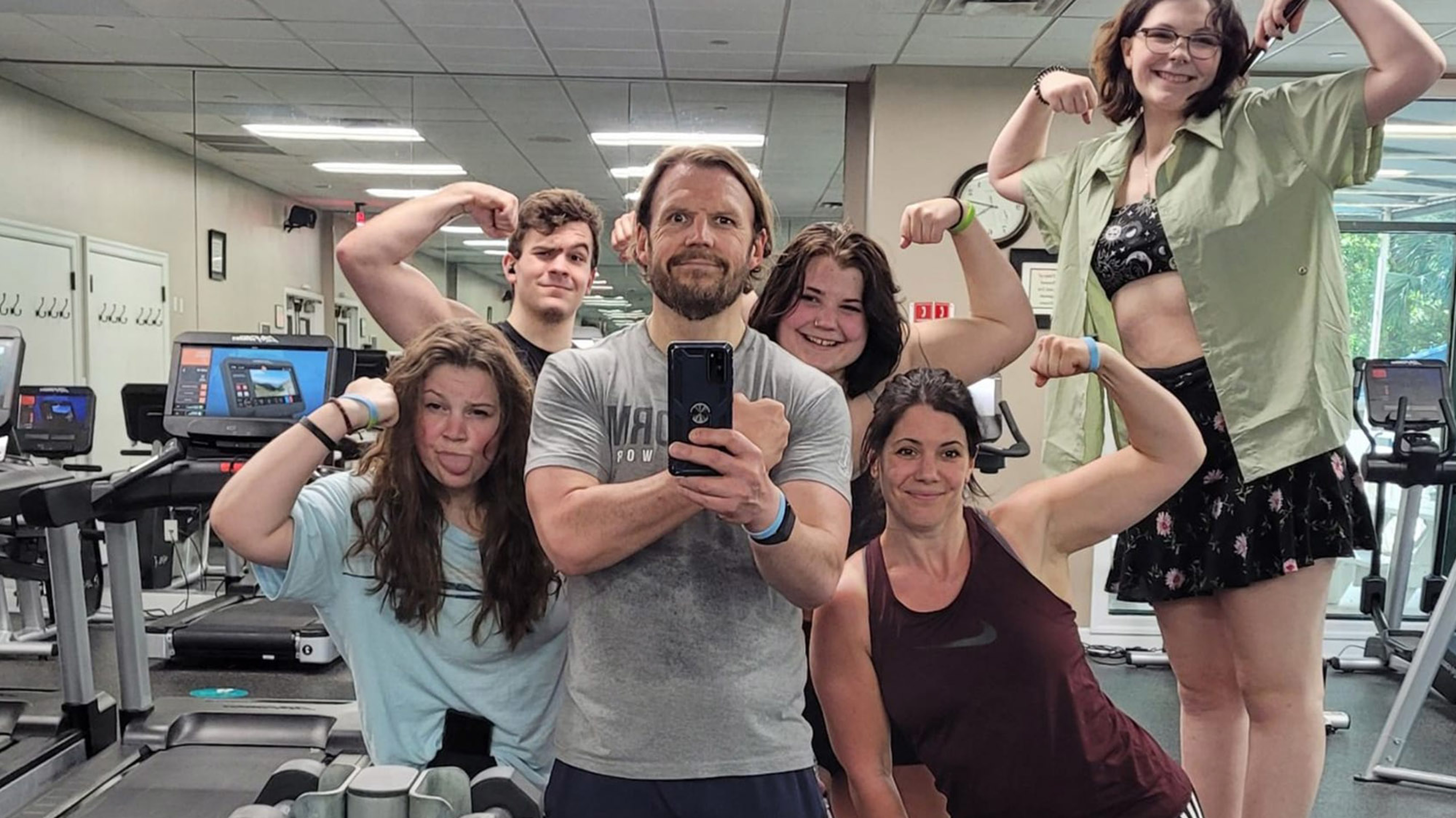 Eric Hall and his family pose in front of a gym mirror after completing a Centr workout.