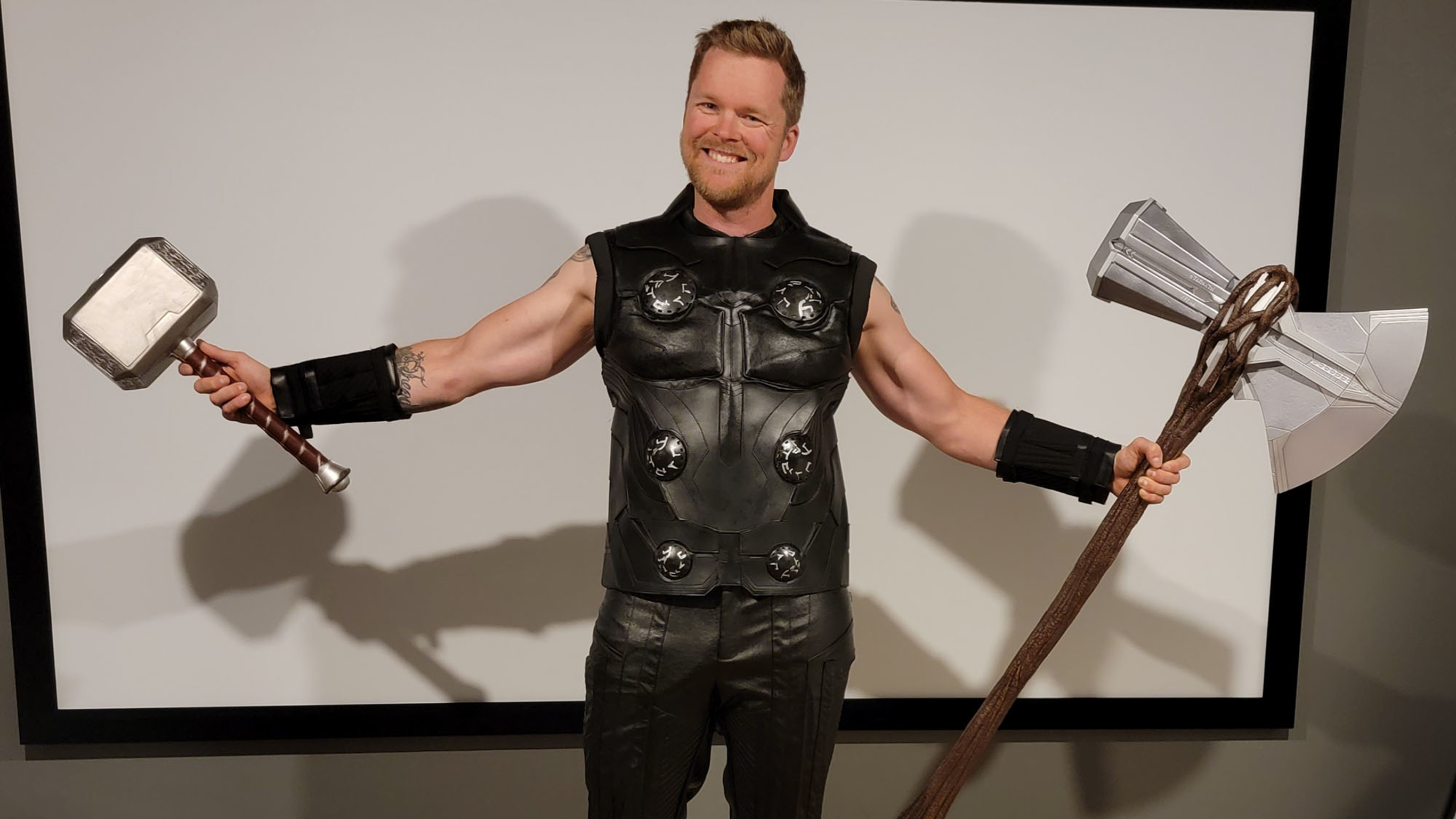 Centr member Mark Haverland, a smiling white man, wears an Infinity War Thor costume while holding a hammer and an axe.