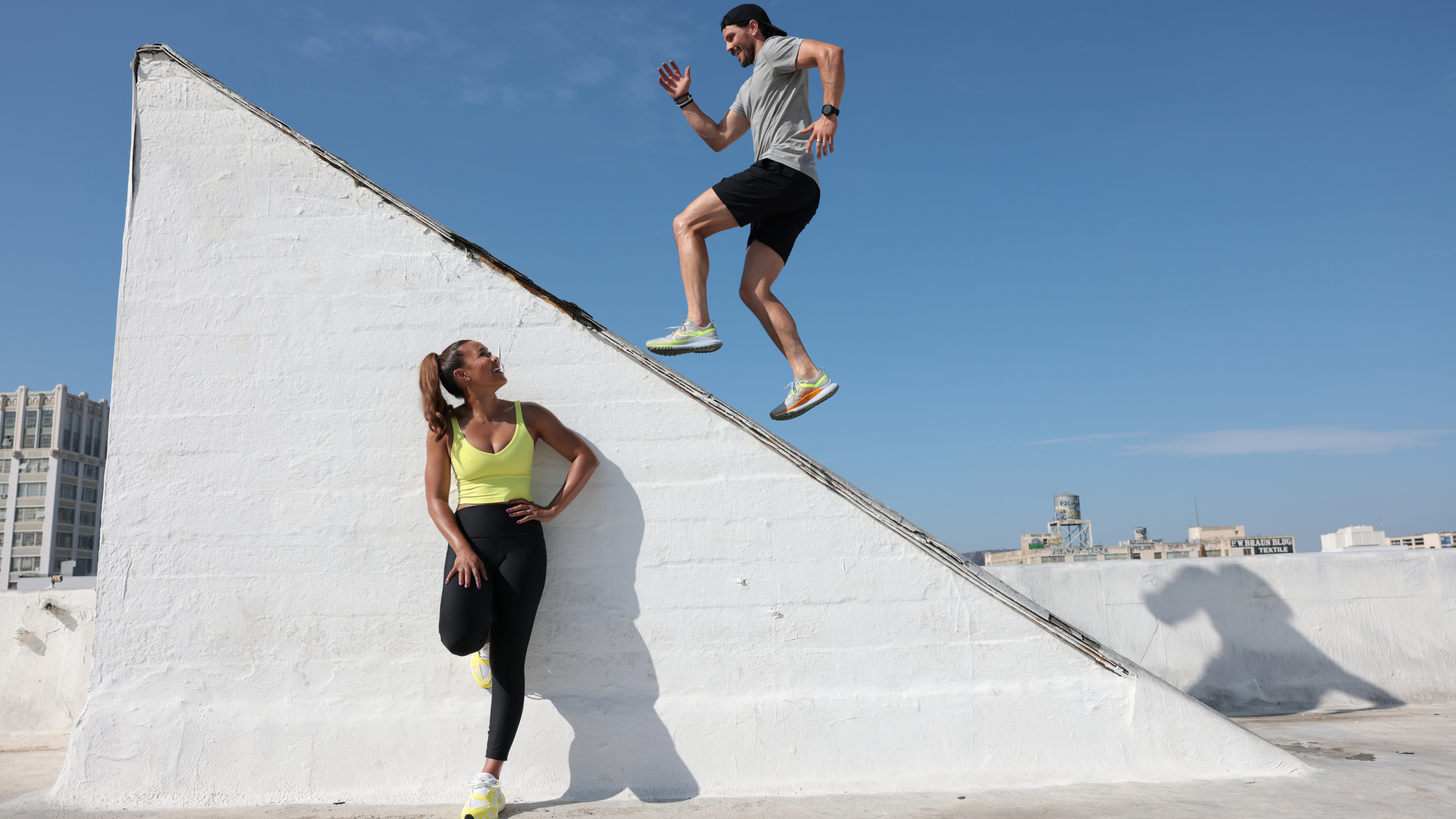 Maricris Lapaix looks up at Dan Churchill as he runs up a slanted wall.