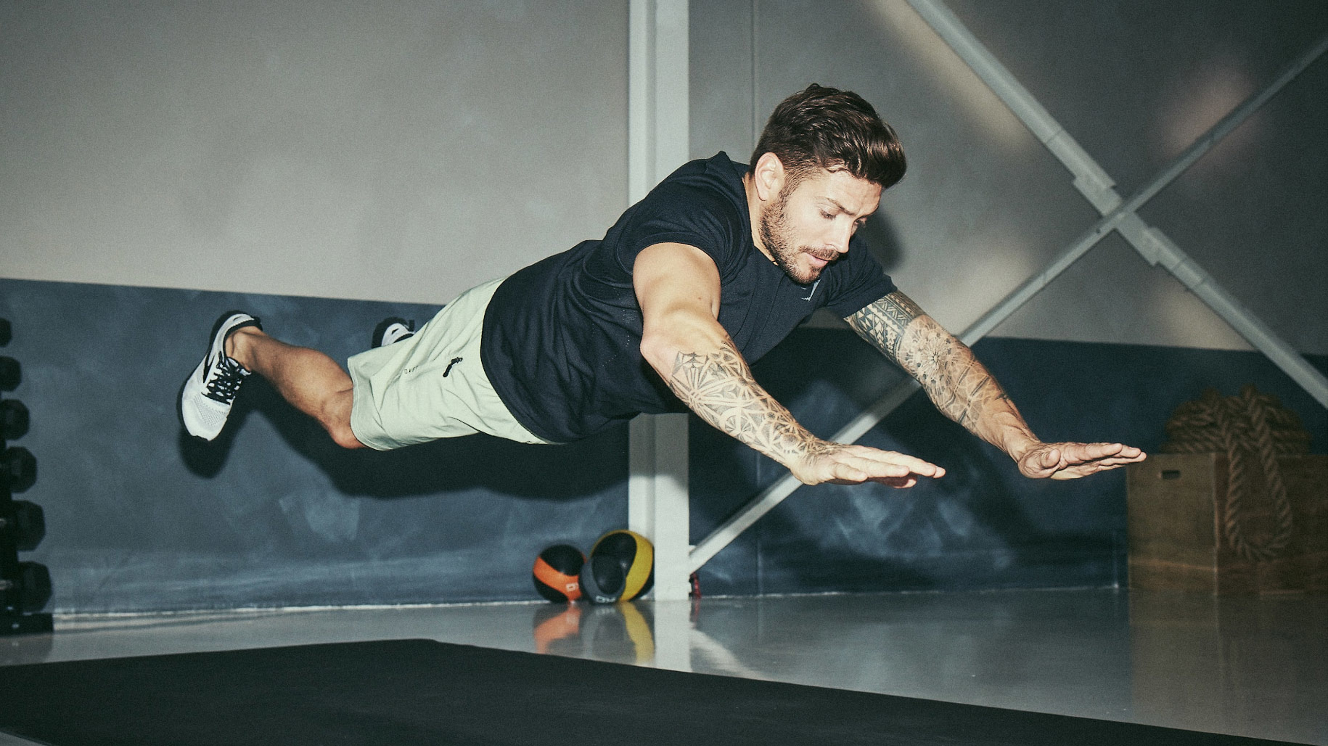 Centr trainer Luke Zocchi is airborne, performing a plyo push-up.