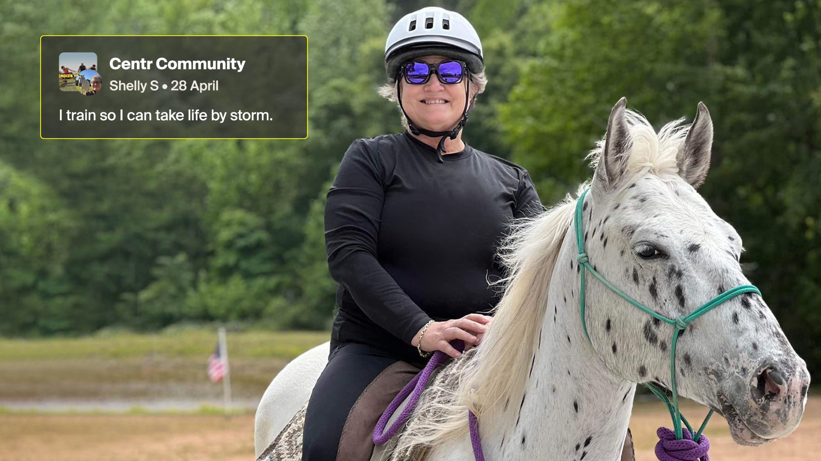Shelley sits on her spotted appaloosa horse in an outdoor arena.