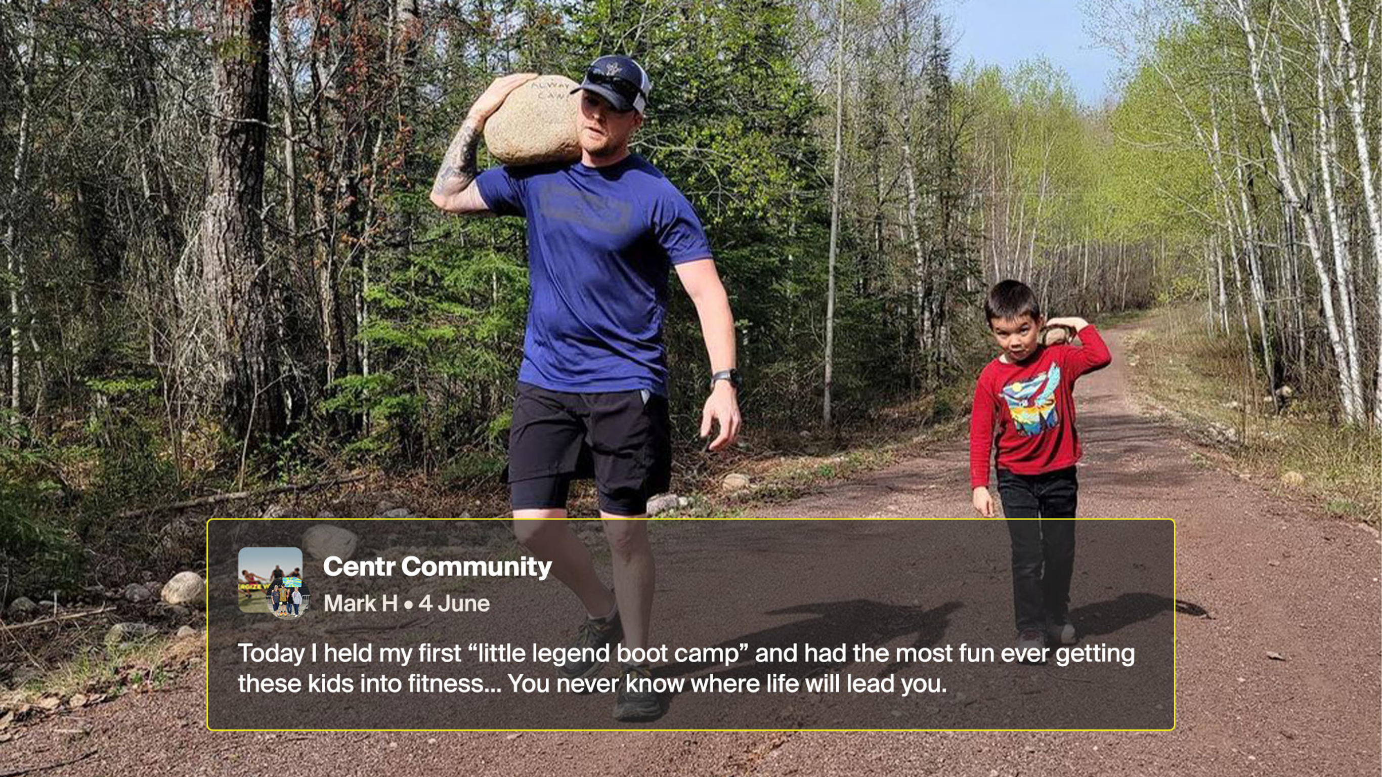 Mark walks alongside a small boy on a country dirt road. Mark carries a large rock on his left shoulder and the boy carries a small rock on his right shoulder.