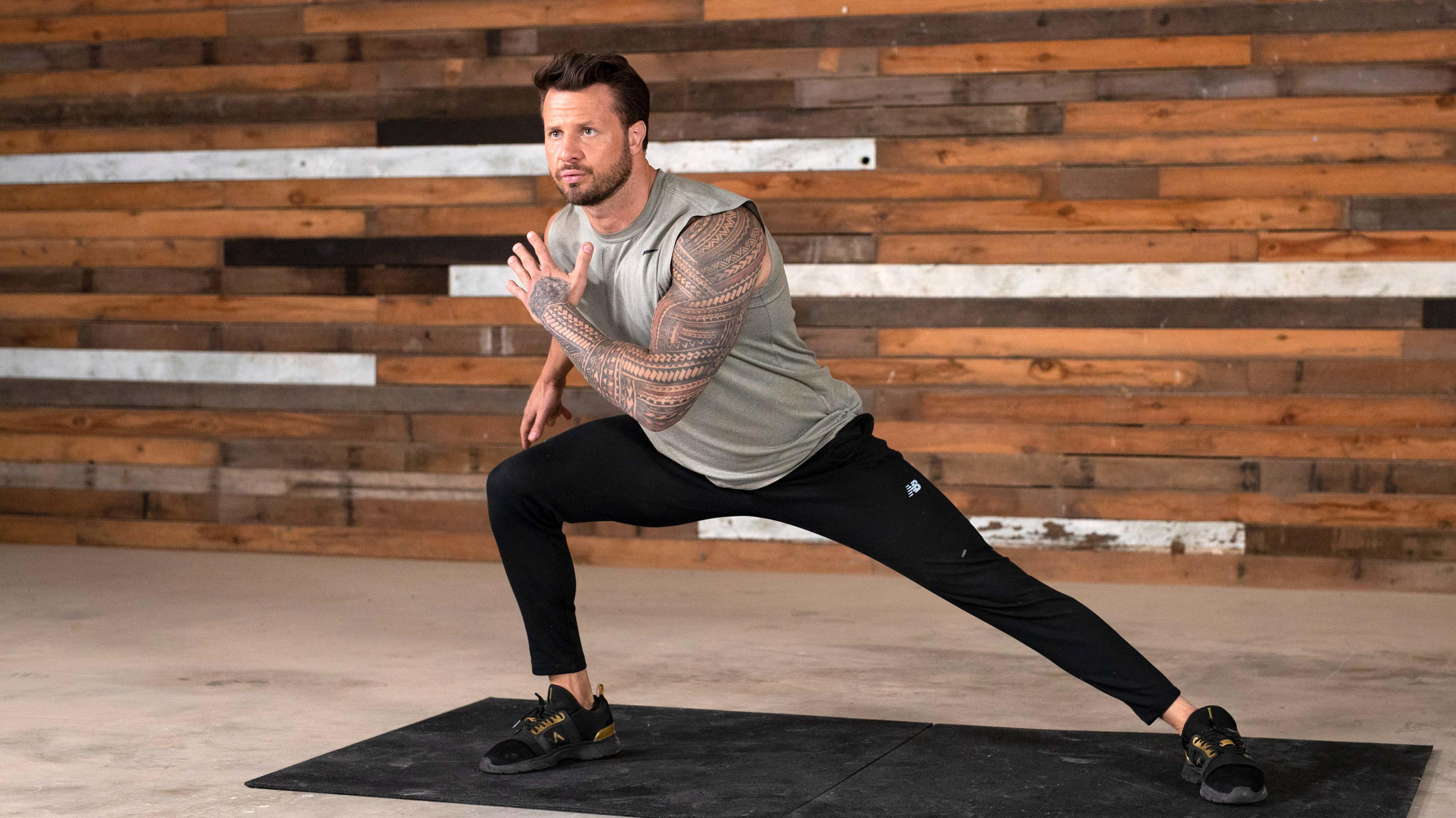 Bobby Holland Hanton  performs a side lunge to the right, looking focused.