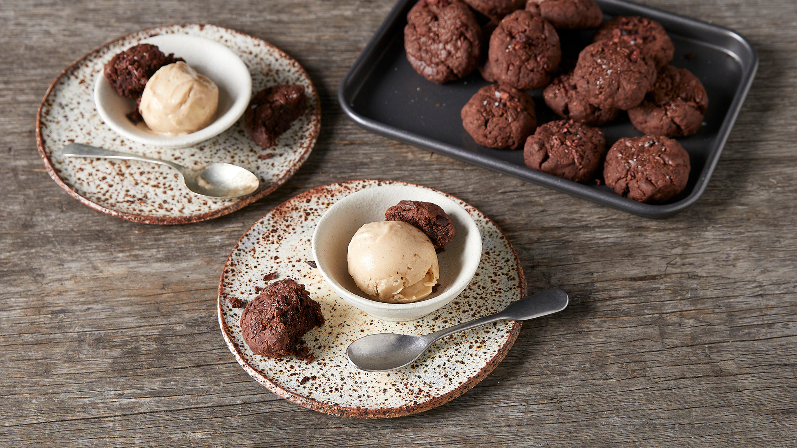 Two servings of Triple Chocolate Cookies with 1-ingredient Ice Cream, from the Centr meal plan, sit on a table alongside a tray of cookies.