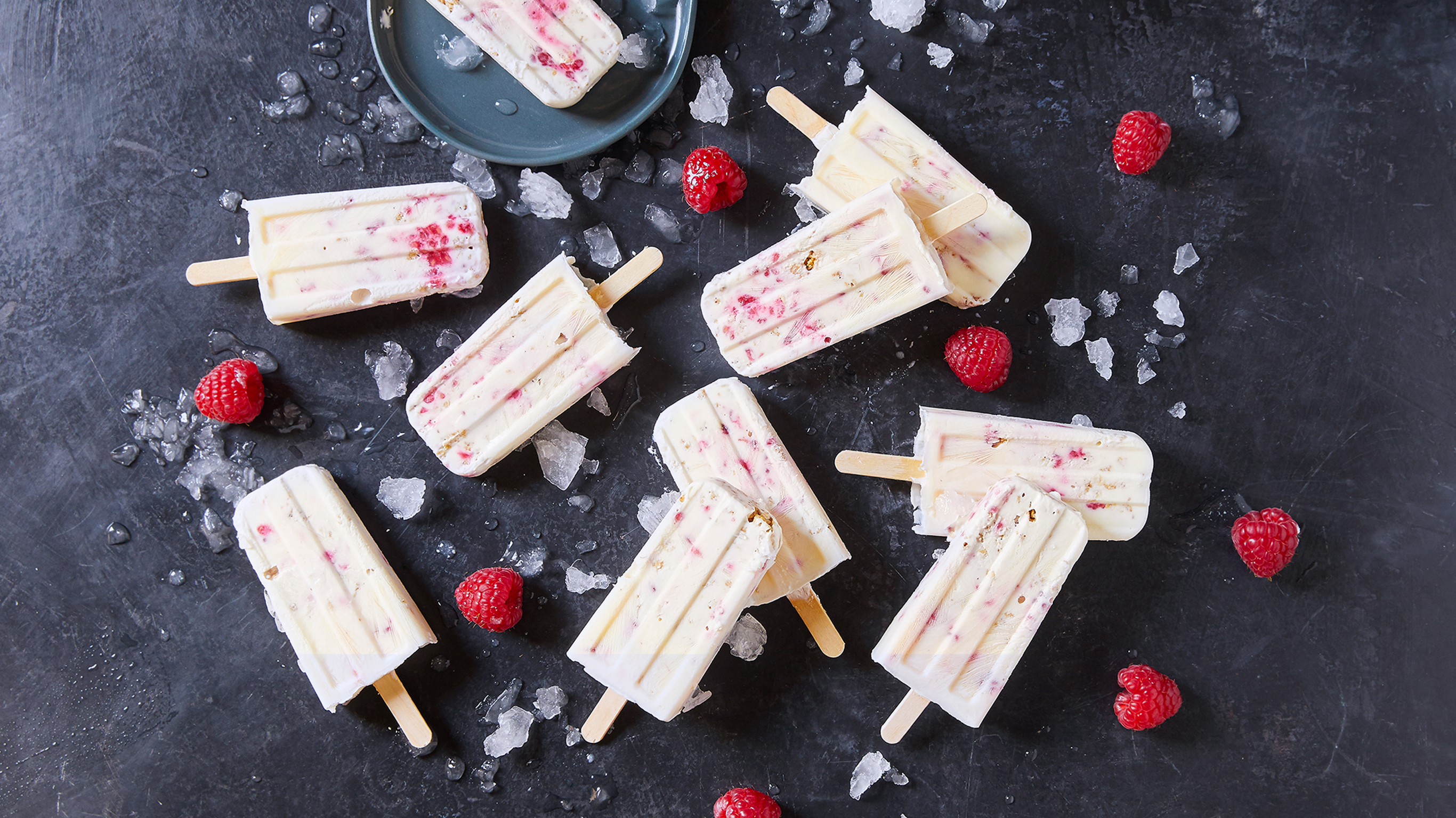 Several Berry Granola Summer Popsicles, from the Centr meal plan, sit on a table.