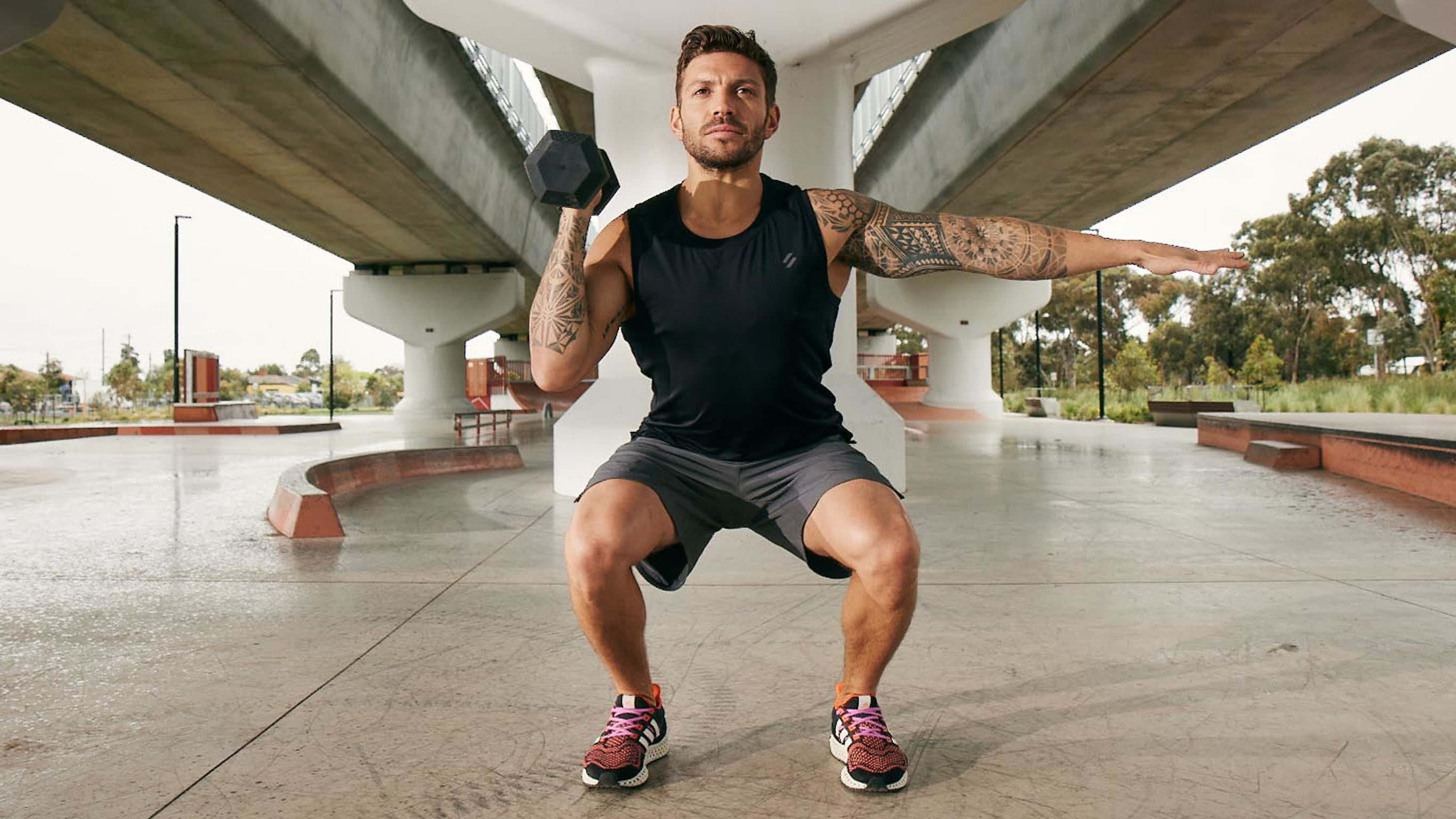 Centr trainer Luke Zocchi weight trains and performs a single-arm squat and press.