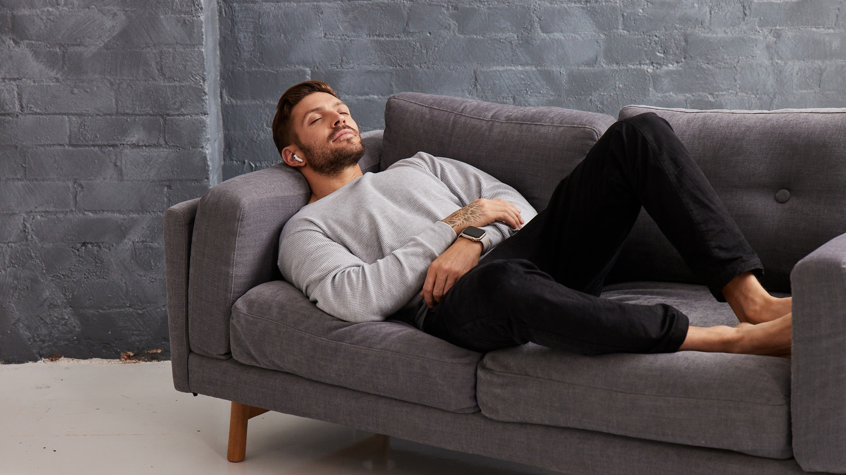 Centr Trainer Luke Zocchi lying on a couch listening to a sleep visulization.