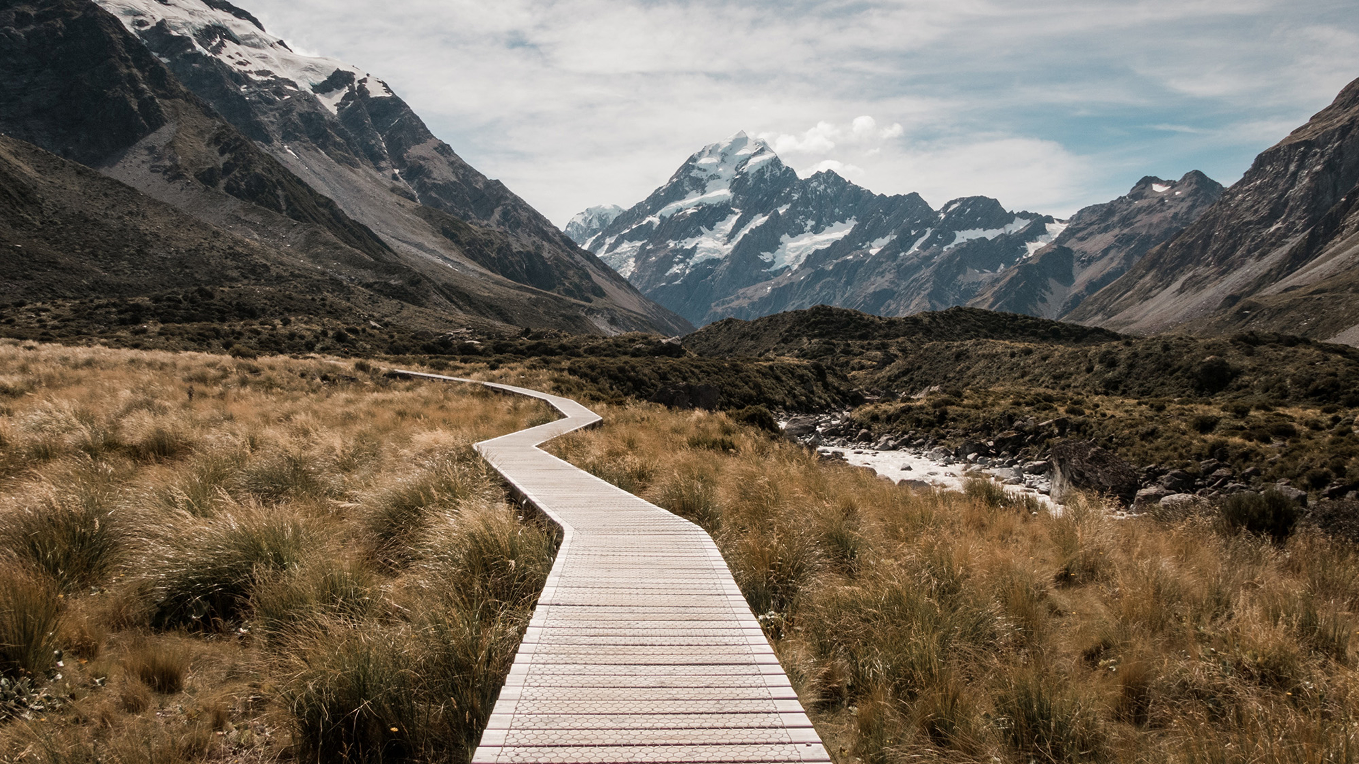 An empty boardwalk leading through a mountain pass.
