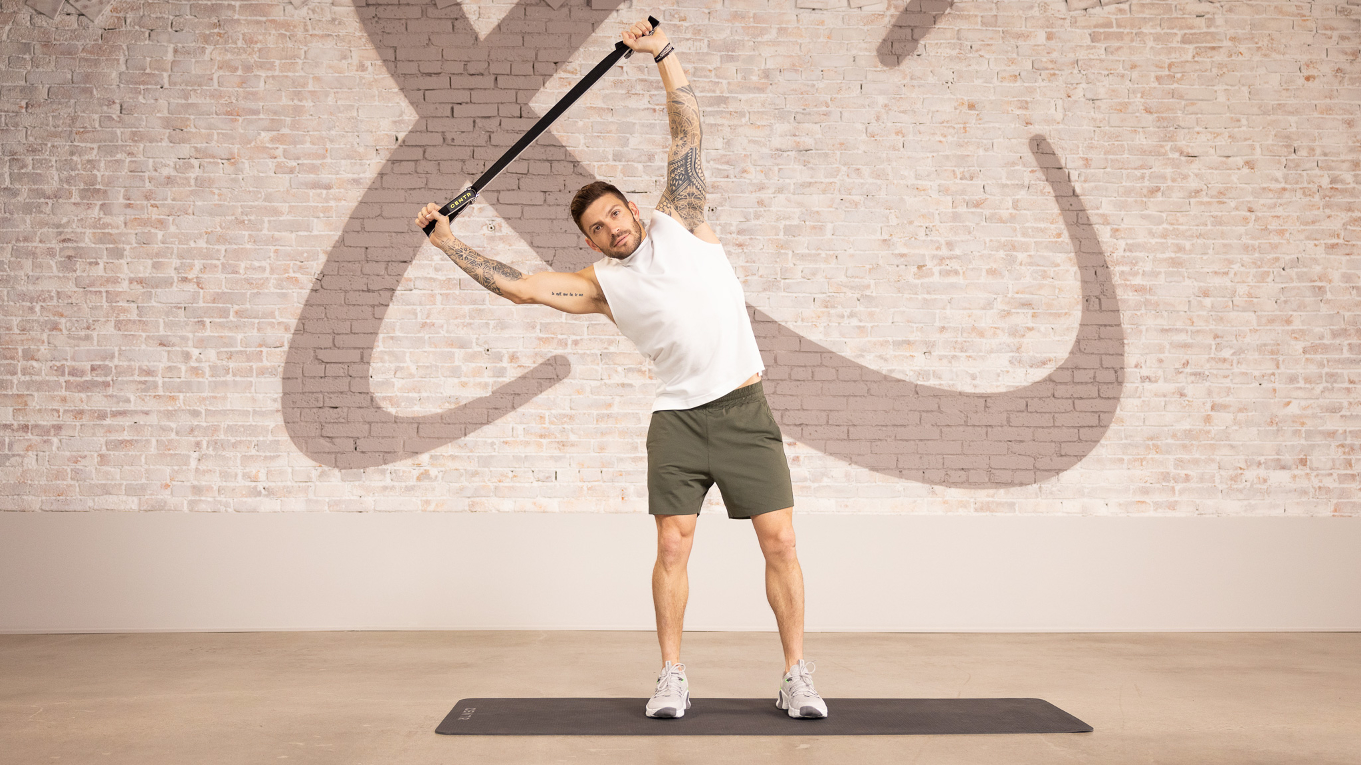Luke Zocchi stretches to the right, holding a strap overhead.