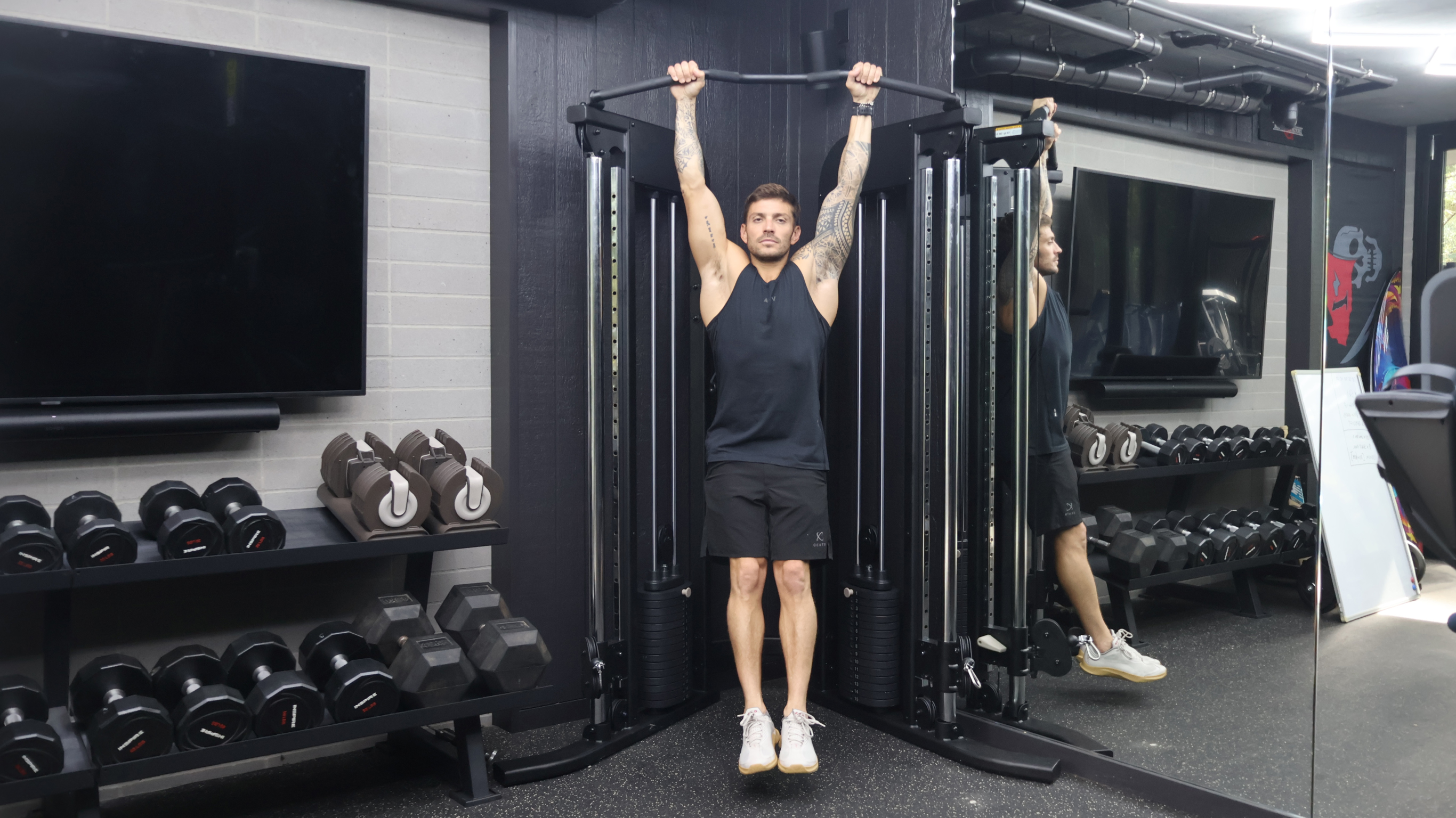 Centr trainer Luke Zocchi demonstrates the hang test, hanging from a chin-up bar.