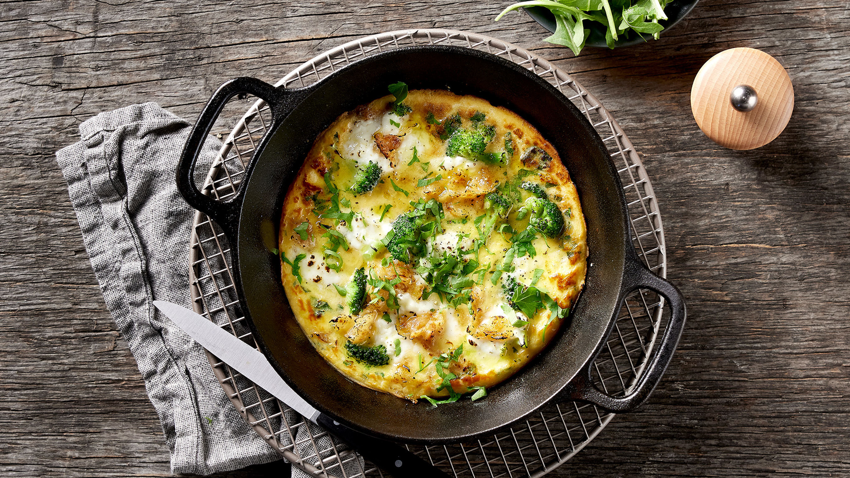 A pan of Dan’s 6-ingredient Weeknight Veggie Frittata sits on a cooling rack, ready to serve.