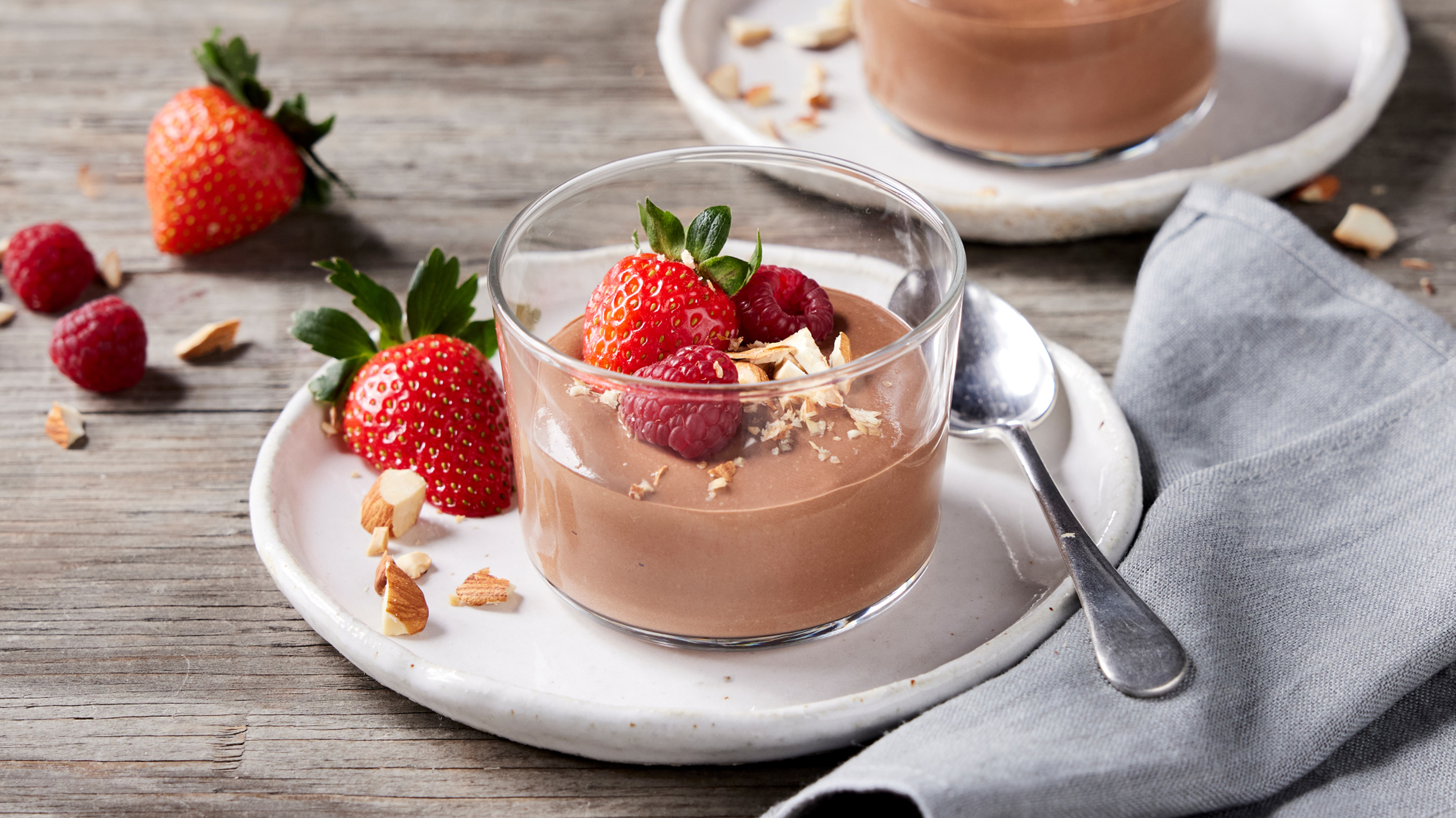 A glass of Mocha Protein Mousse sits on a white plate, ready for eating.