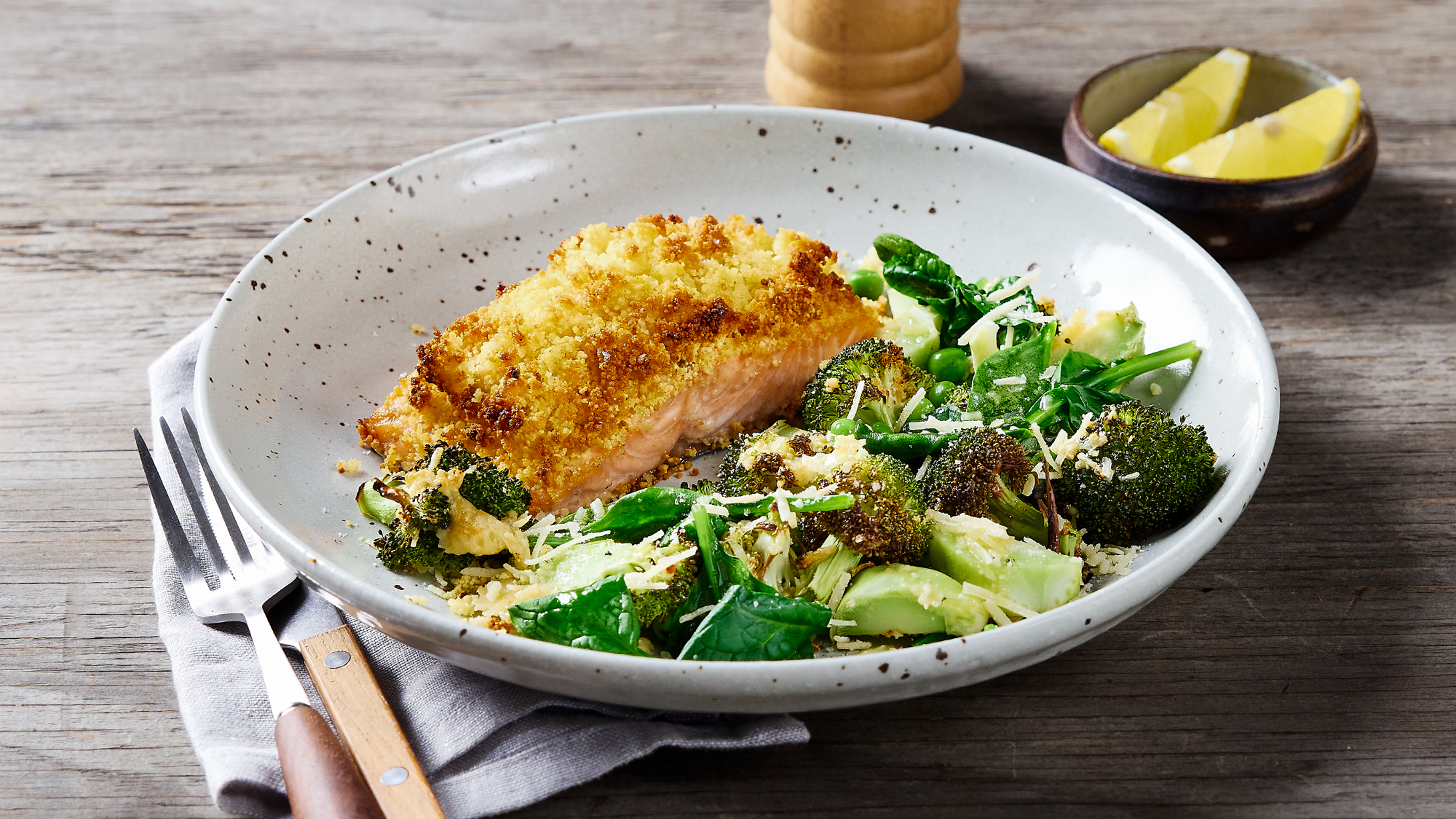A bowl of Air Fryer Couscous Salmon & Roasted Broccoli Salad, from the Centr meal library, sits on a table.