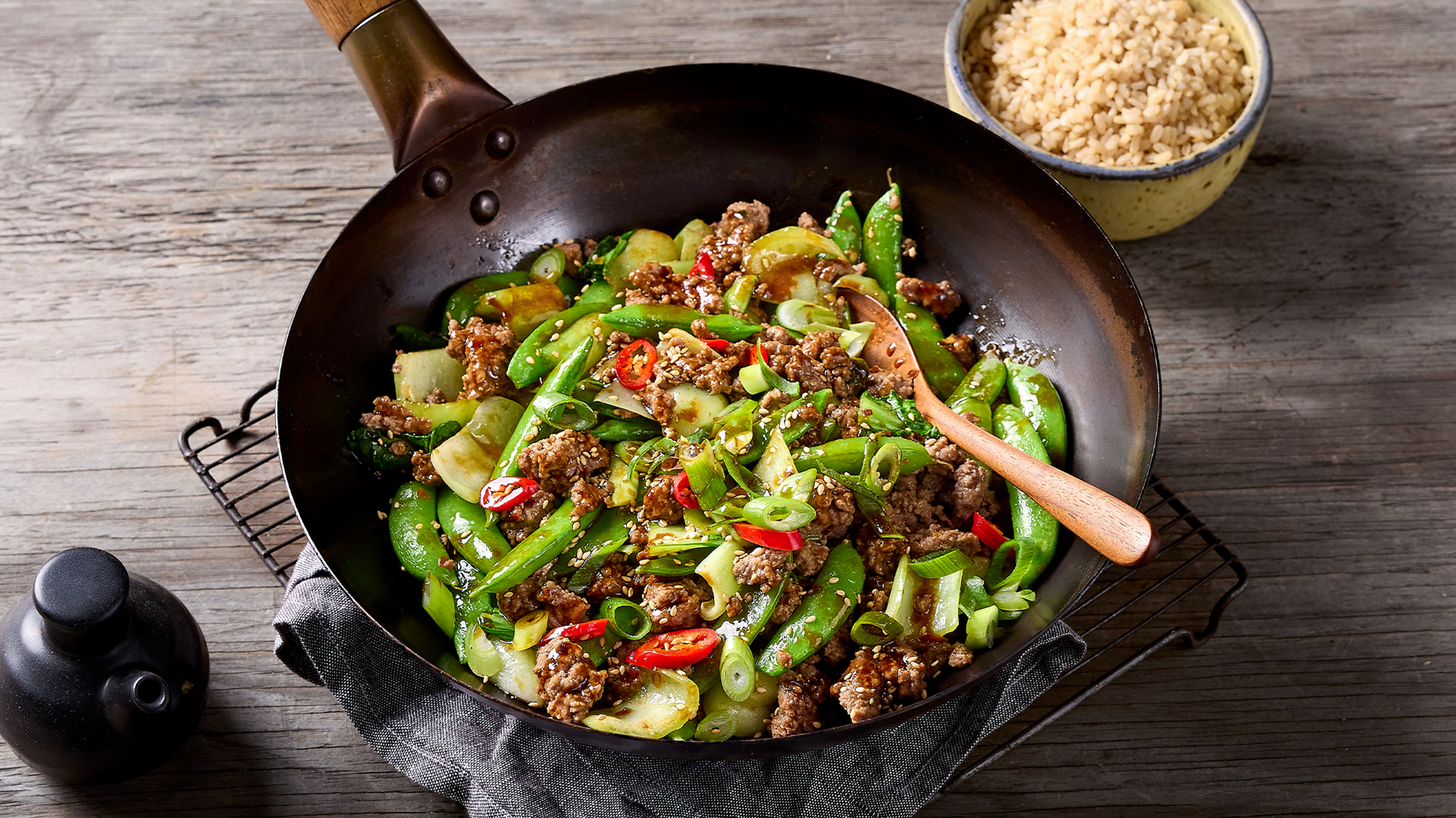 A wok of Easy Beef & Greens Stir-fry, from the Centr meal library, sits on a table.