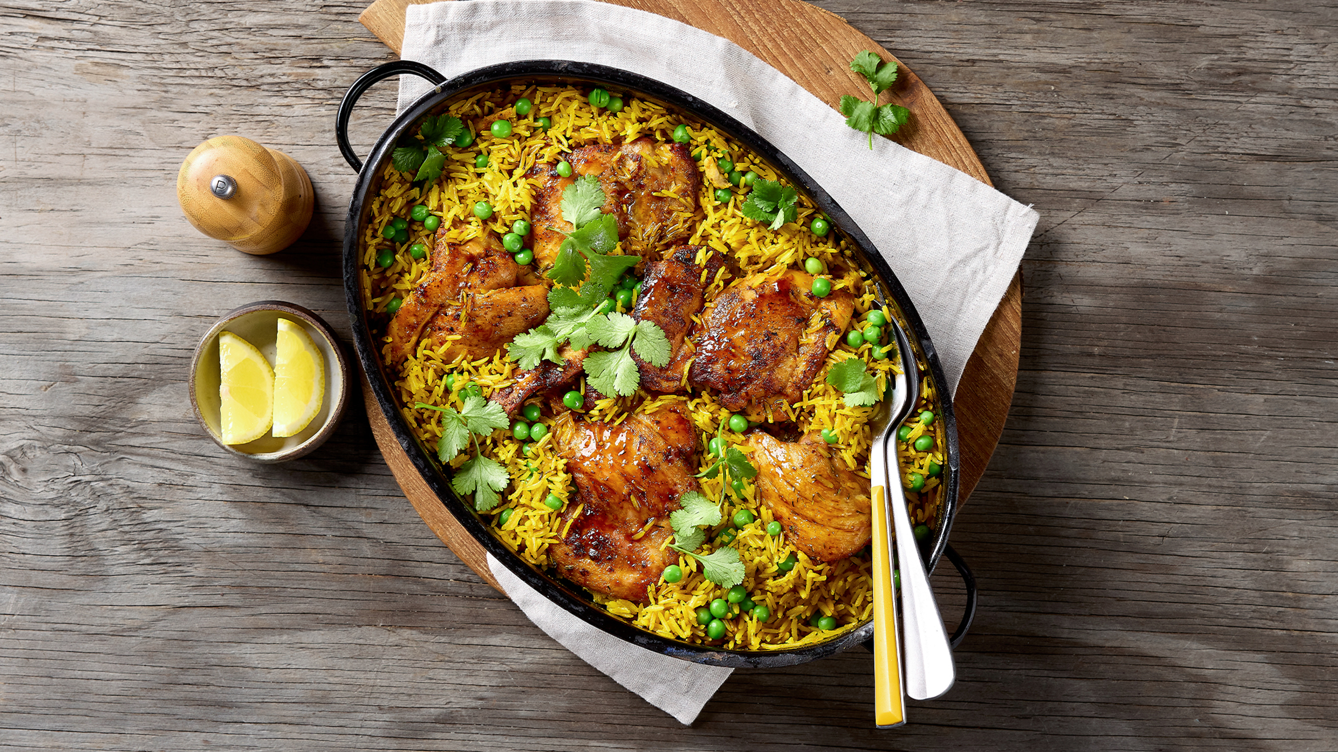 A pan of One-pan Turmeric Chicken, Rice & Pea Bake, from the Centr meal library, sits on a table.