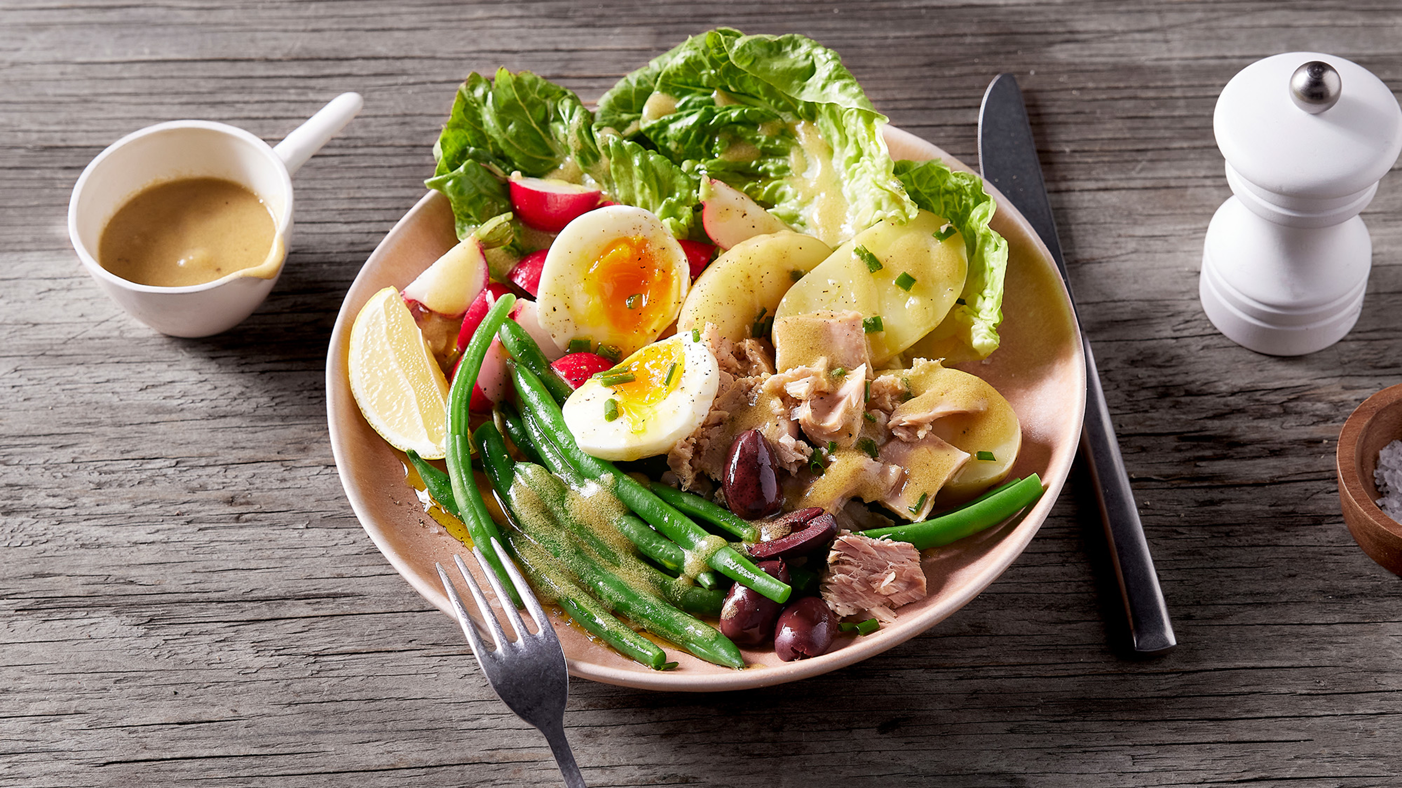 A plate of Centr's Weekday Tuna Nicoise Salad sits in a table ready for eating.