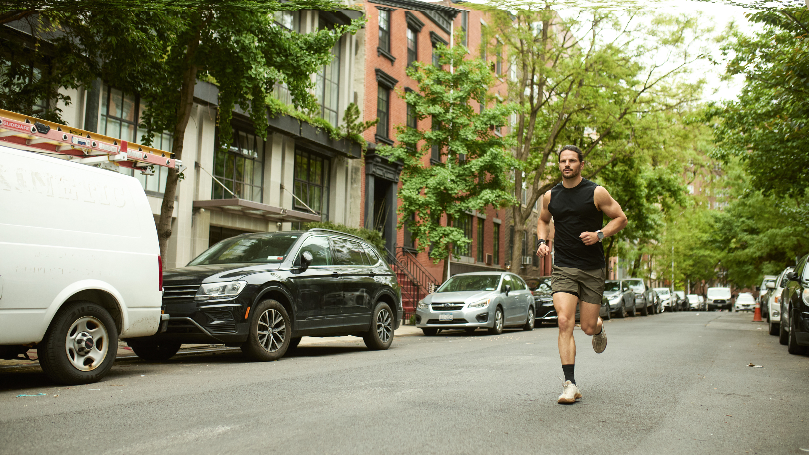 Centr trainer Dan Churchill runs down a tree-lined city street.