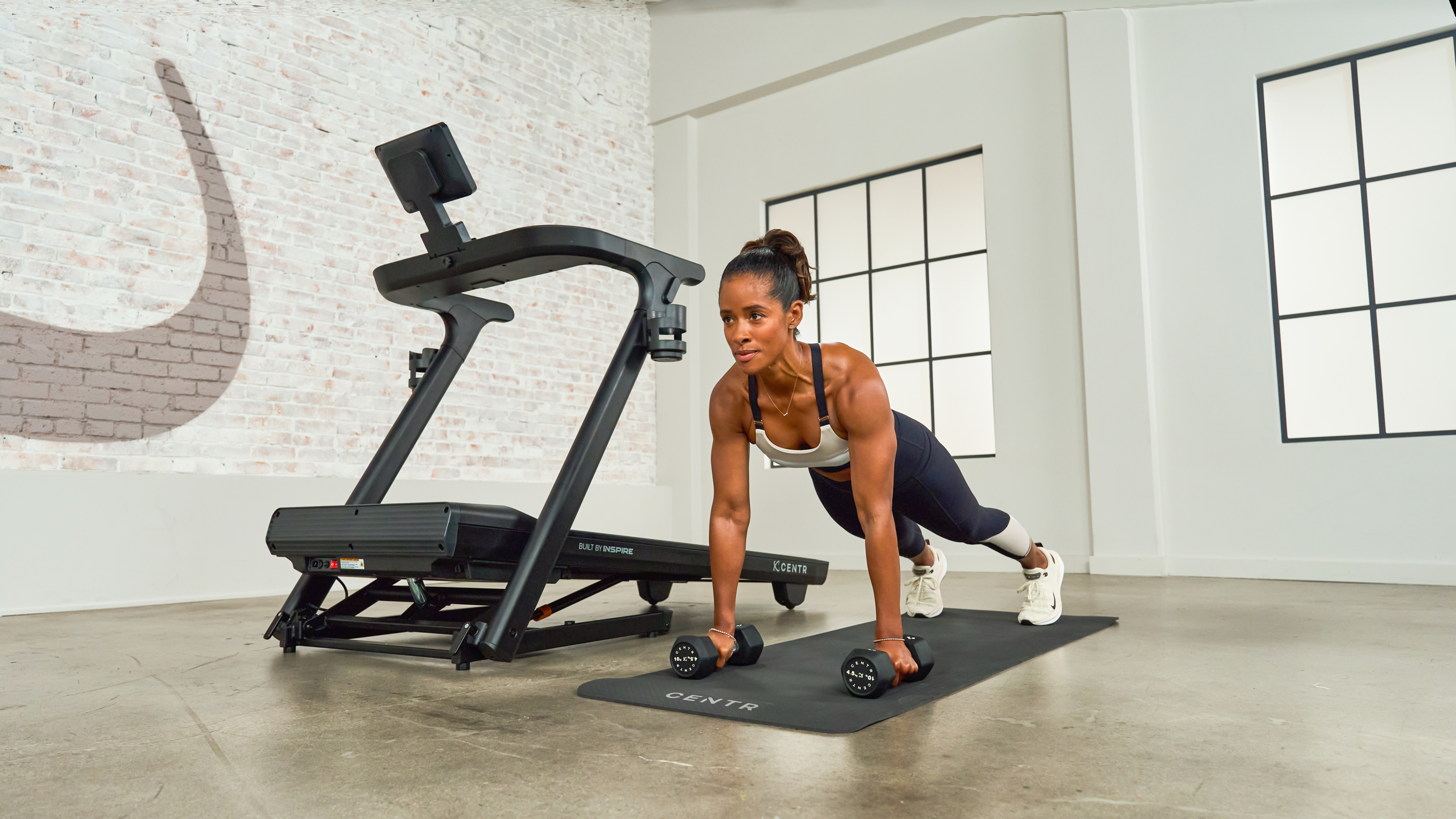 Centr trainer Ingrid Clay performs a dumbbell plank as part of a Strength for Runners workout.