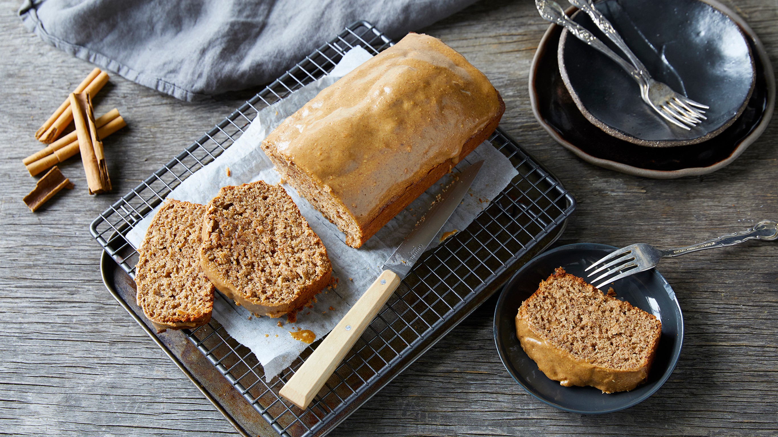 Centr's Gingerbread Loaf with Almond Drizzle sits on a cooling rack, sliced and ready for serving.