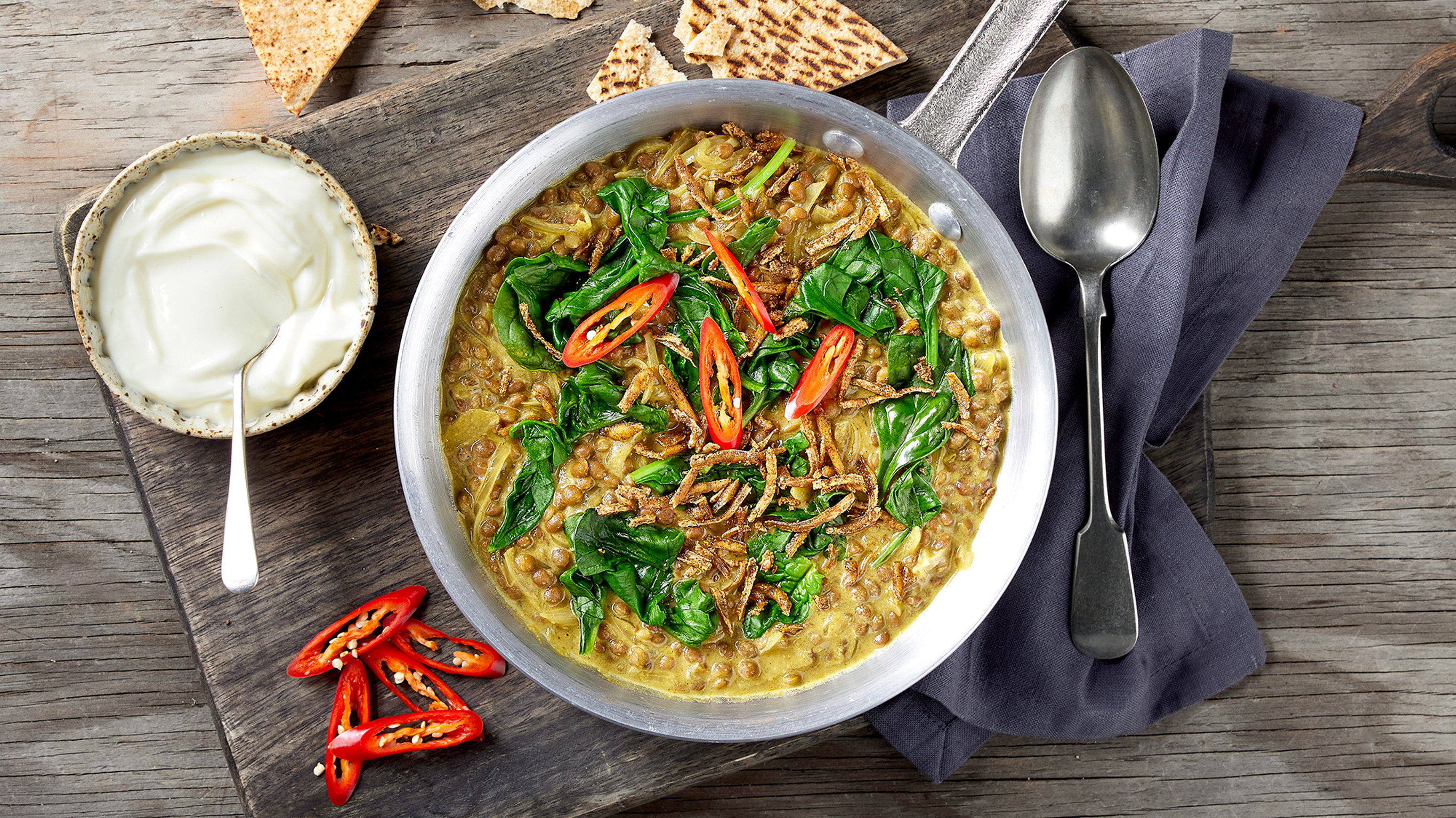 A skillet of Centr's High-protein Lentil Braise with Flatbread is ready for serving.