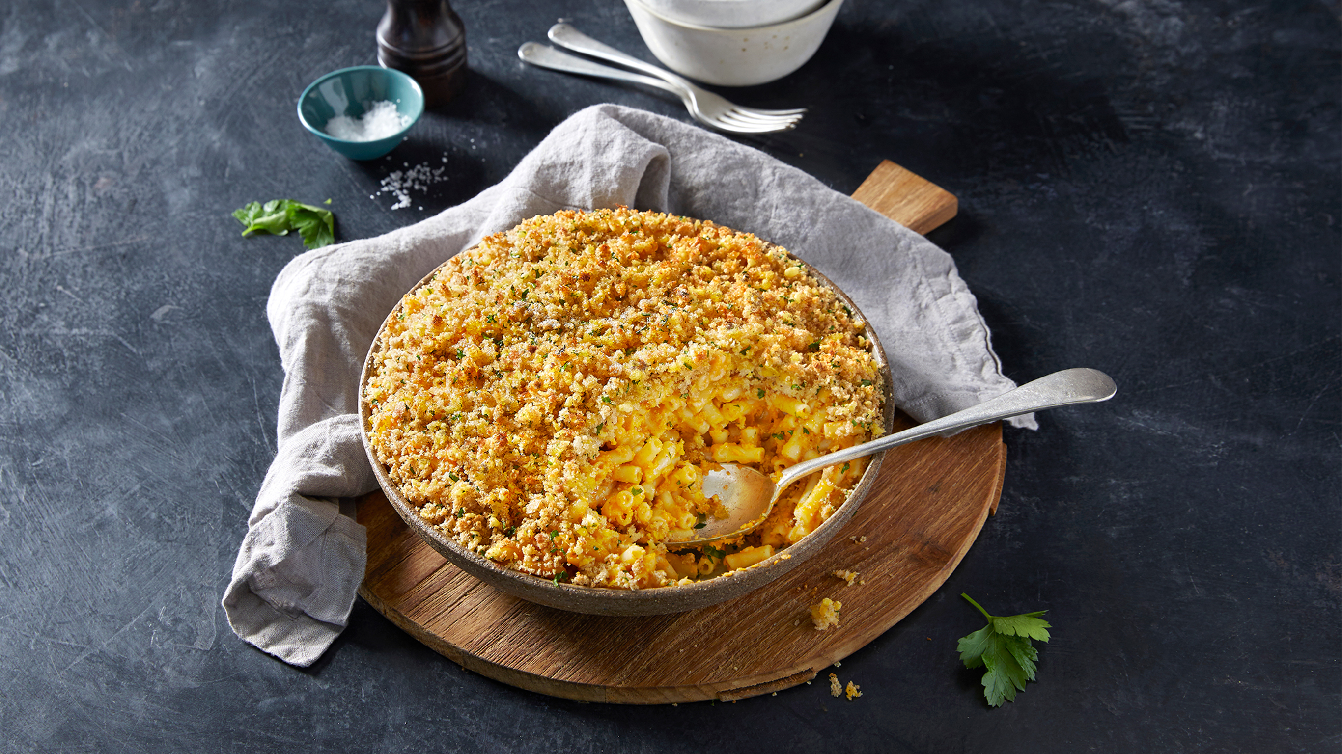 A large serving bowl of Centr's  Vegan Mac & Cheese with Crunchy Topping is ready for serving