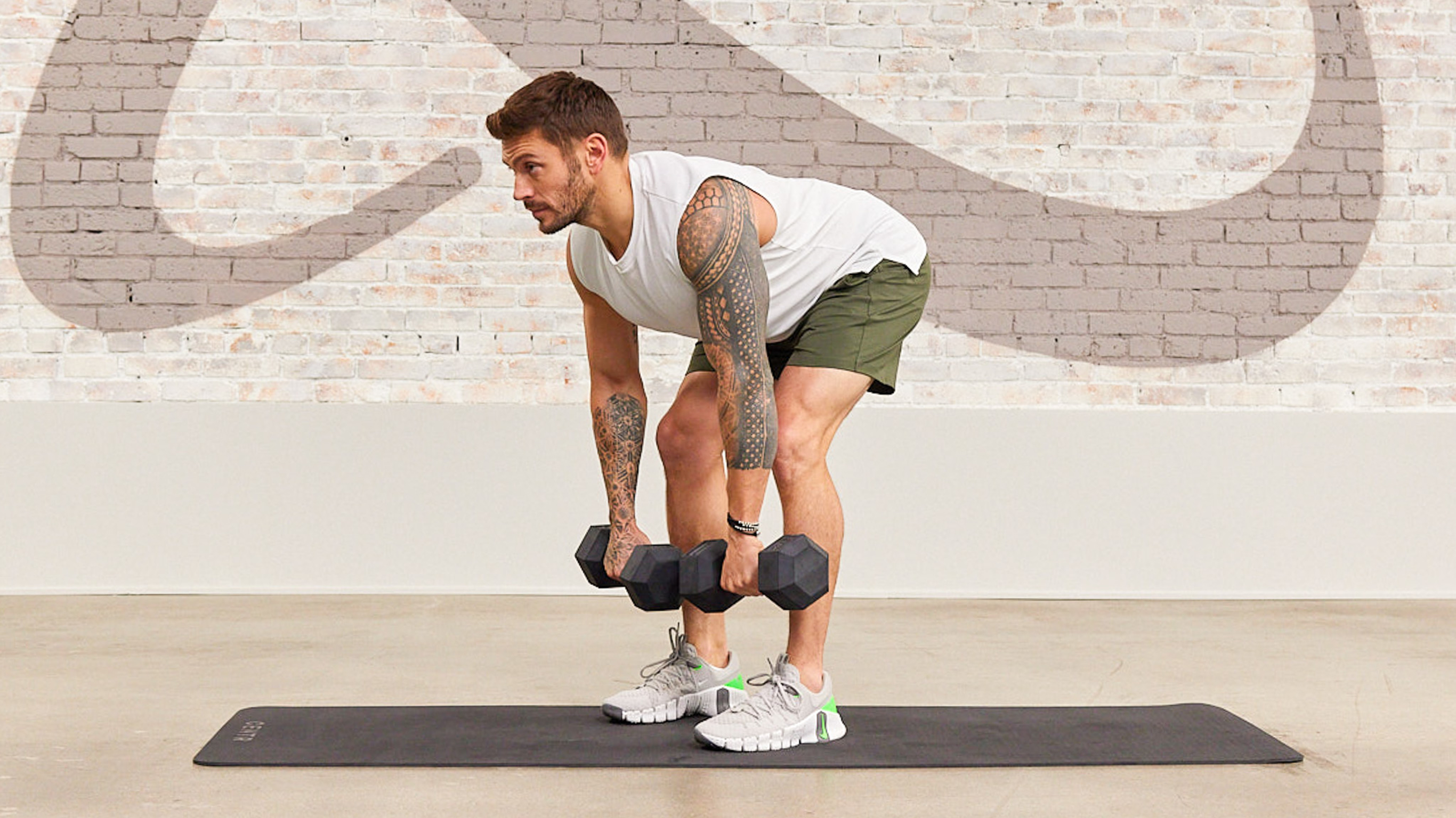 Luke Zocchi performs a Romanian deadlift using Centr's hex dumbbells.