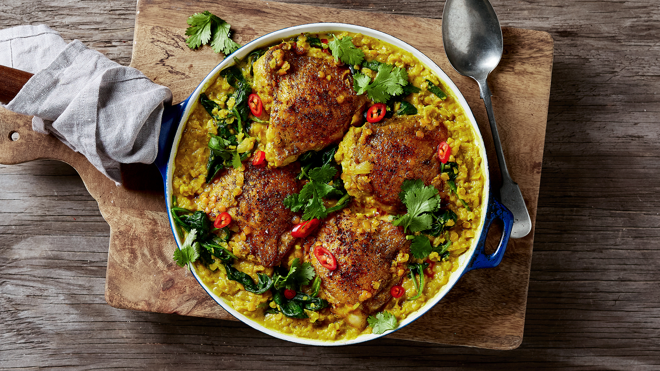 A round dish of Centr's Baked Curried Chicken with Red Lentils is ready for serving.