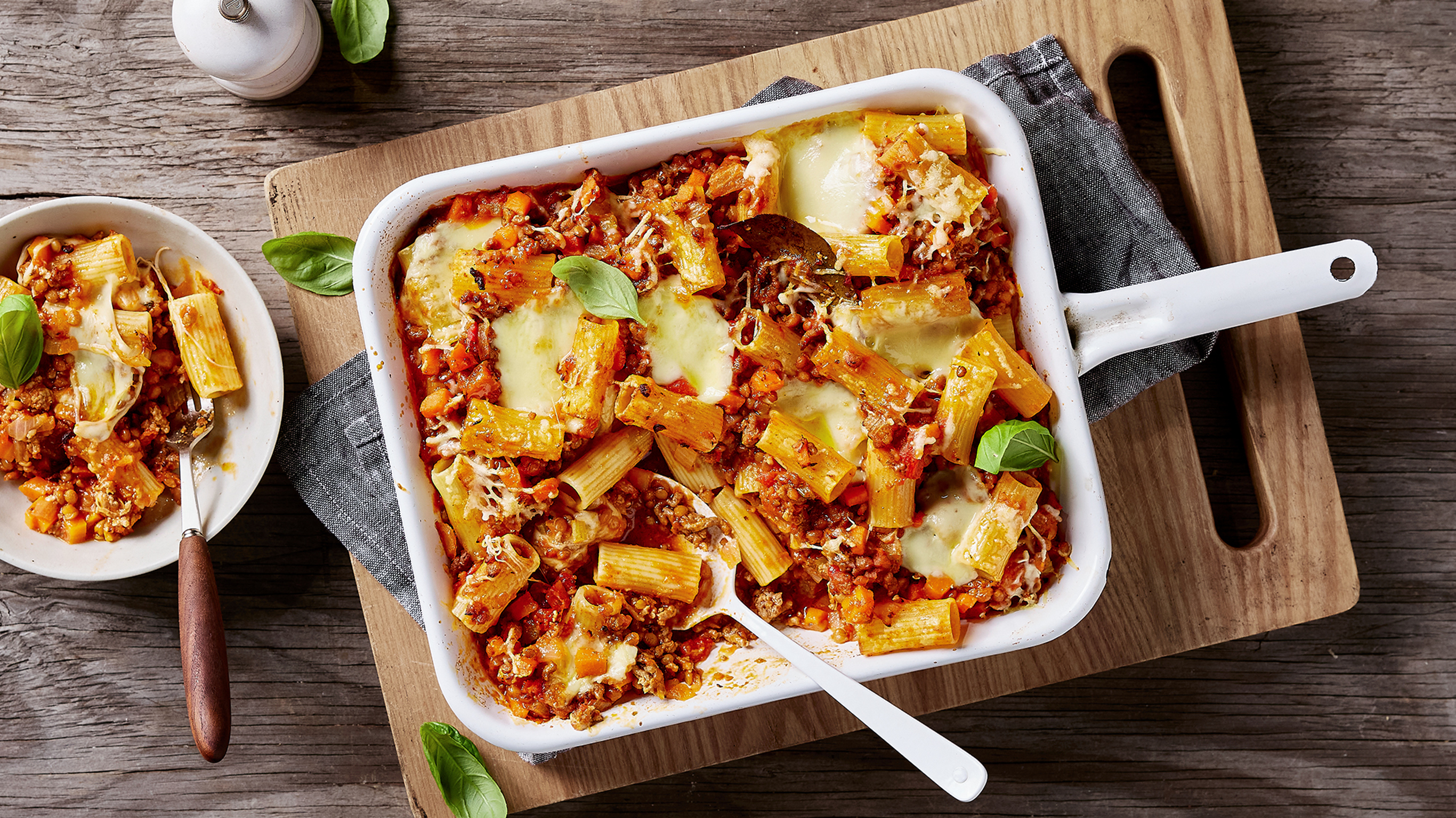 A ceramic pan of Half & Half Bolognese Pasta Bake from the Centr menu  is ready for serving.