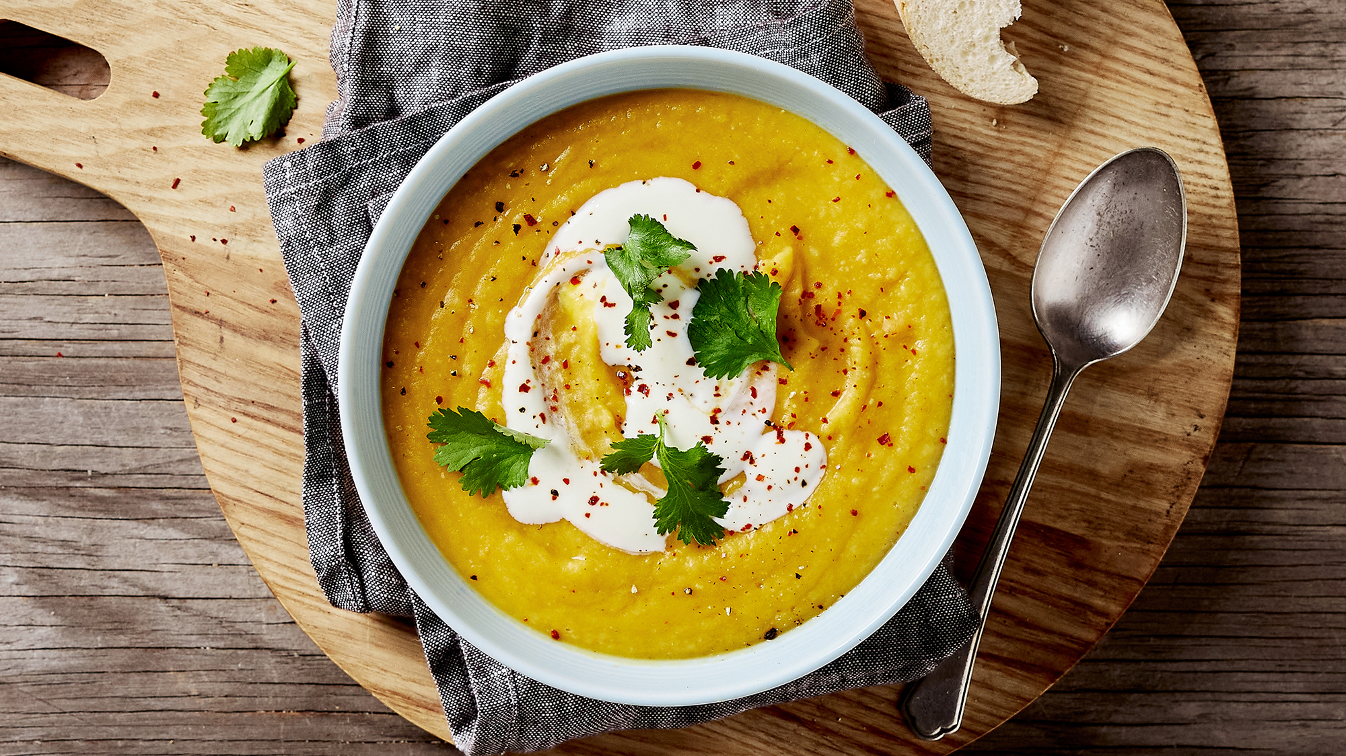 A bowl of Centr's Red Lentil Harvest Soup, with greek yoghurt swirled through, is ready for eating.