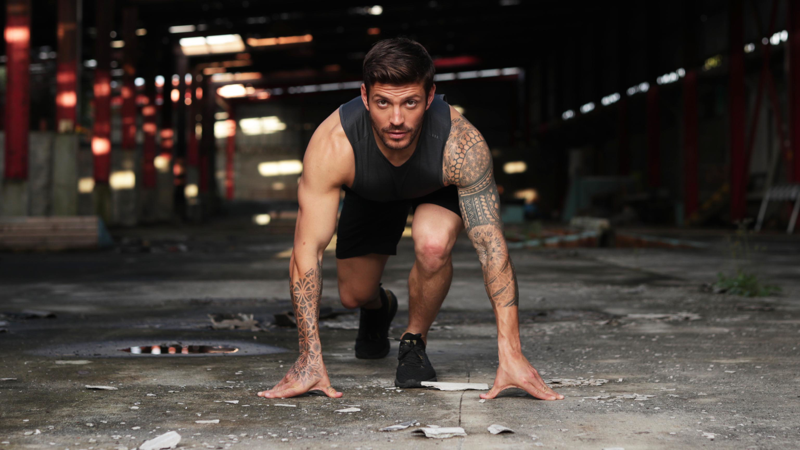 Luke Zocchi looks at the camera head on, while in a low starting position in an abandoned warehouse.