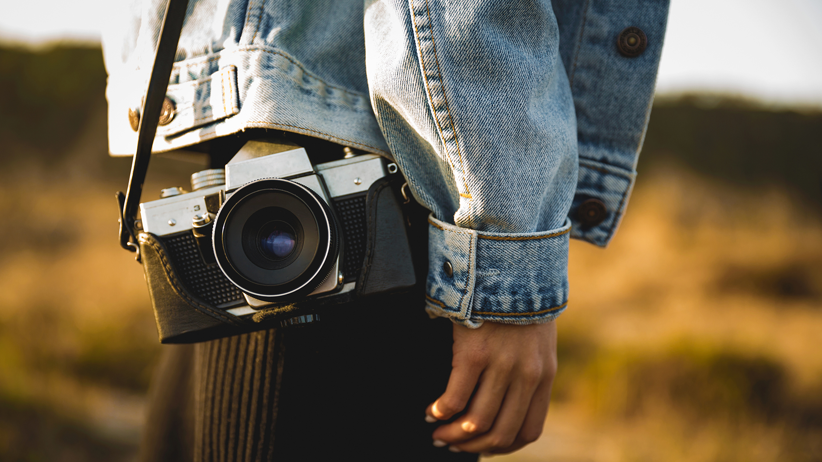 A close-up of a camera slung over a woman's shoulder.